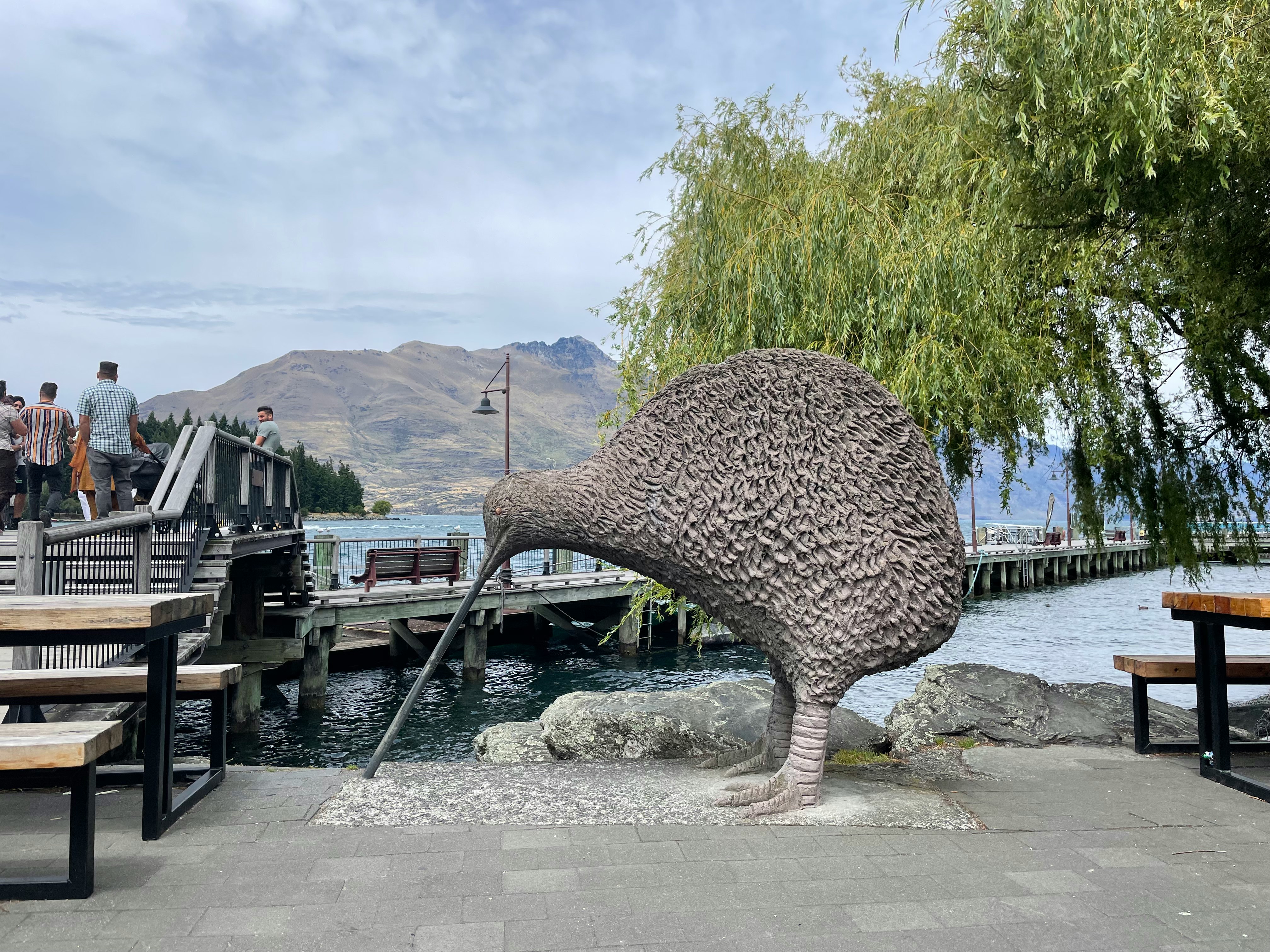 gran escultura de tortuga en un paseo junto al agua con bancos