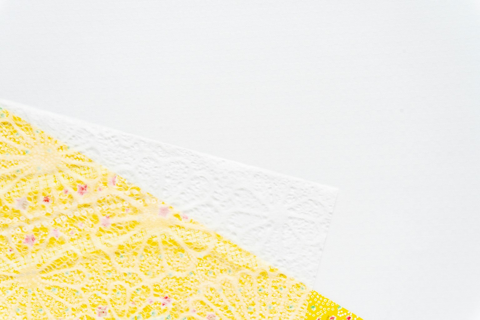 Pizzo giallo e pizzo bianco sovrapposti su uno sfondo bianco