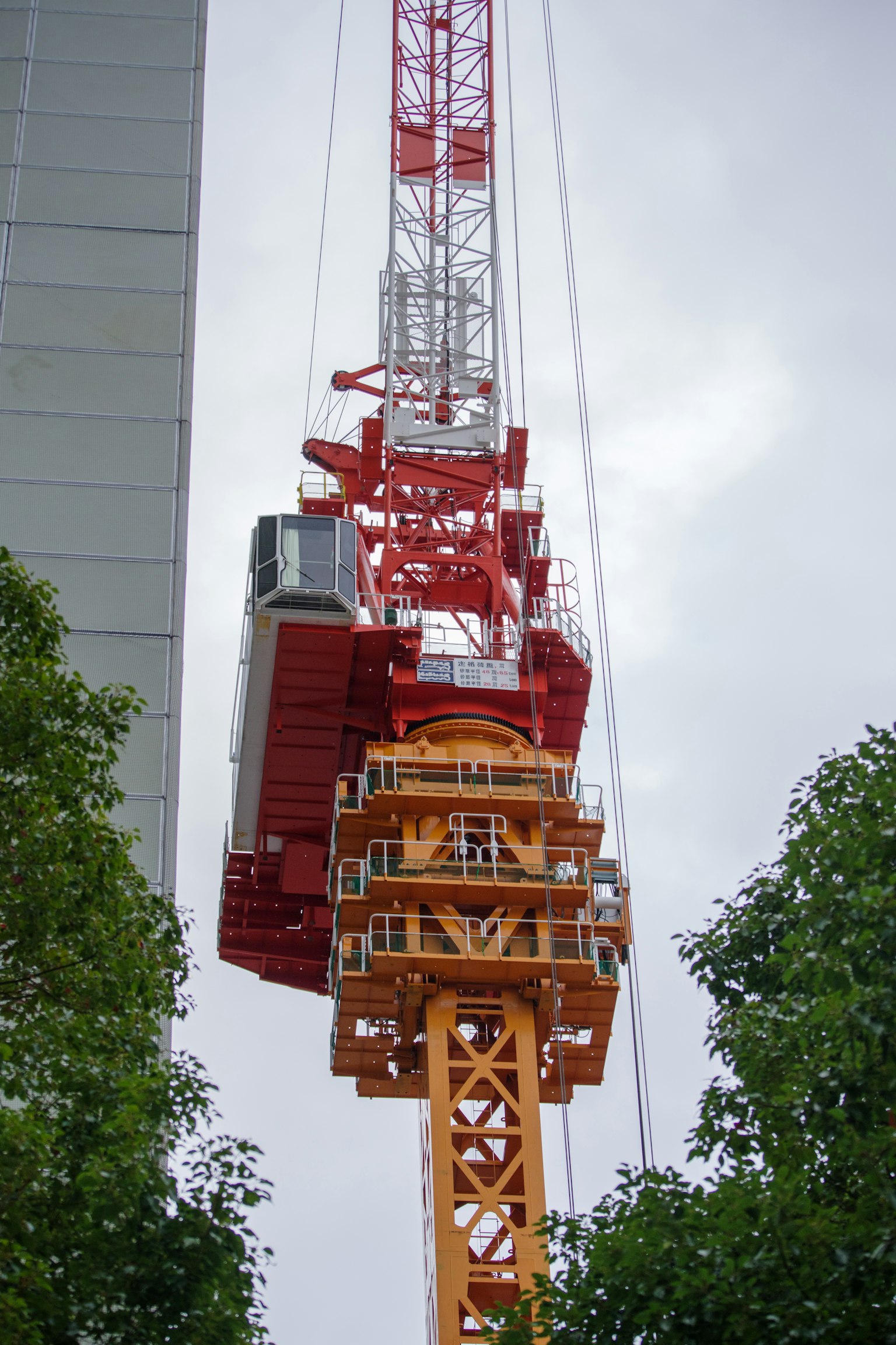 Detailed image of a construction crane featuring striking red and orange colors