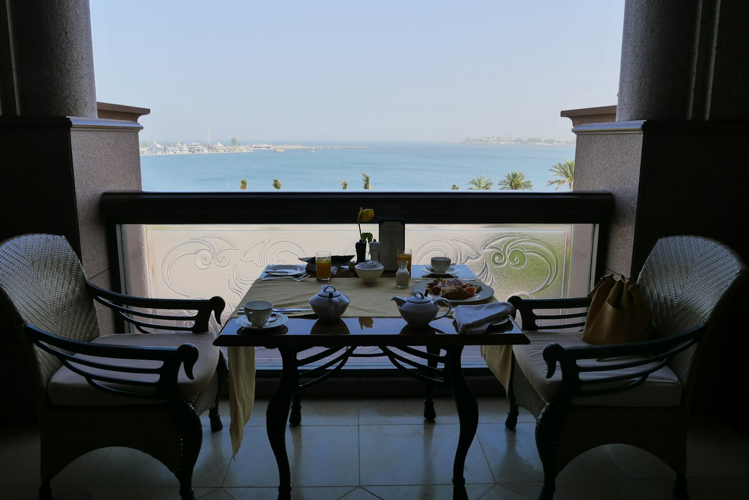Table set for breakfast with a view of the sea and two chairs