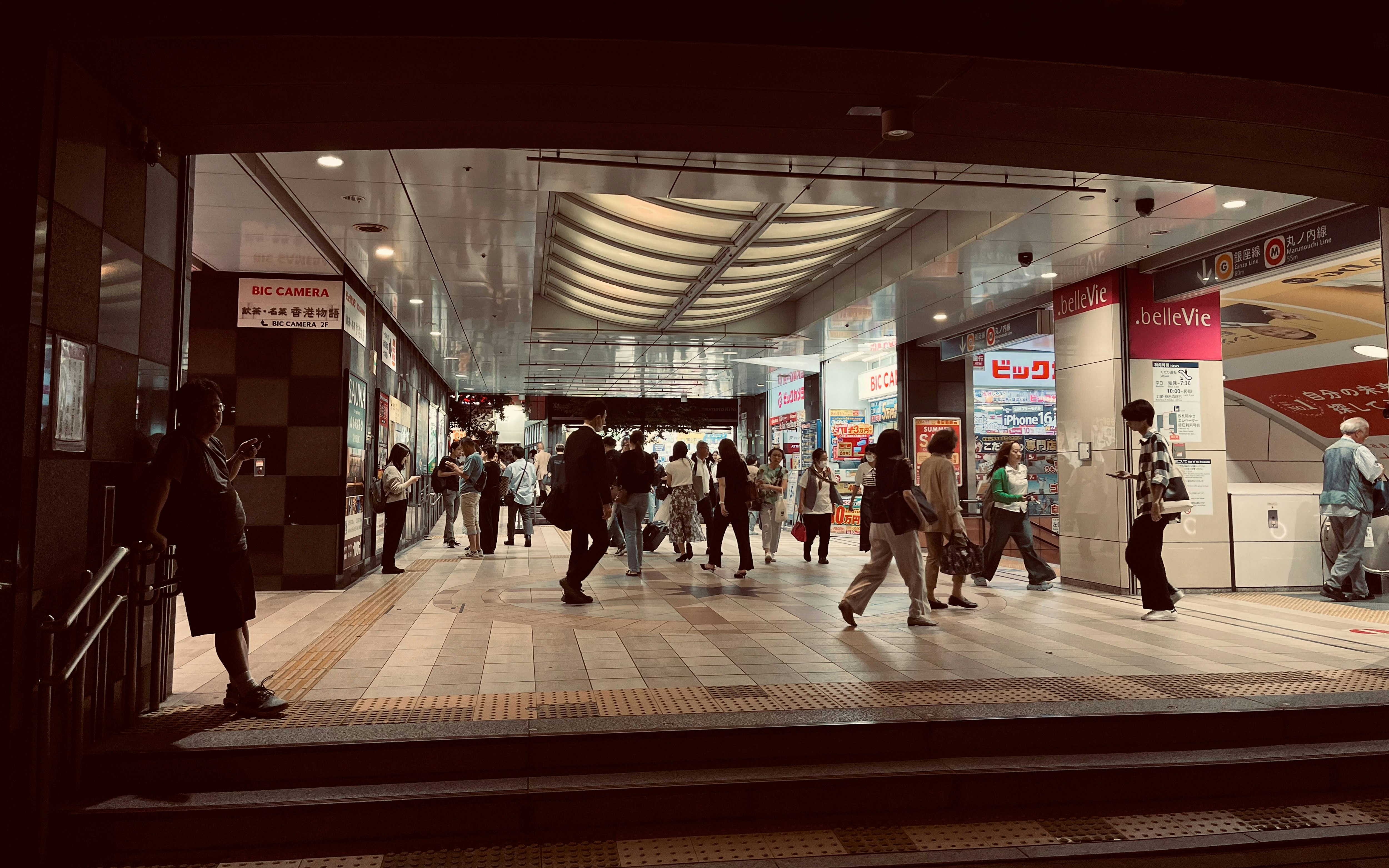people walking through a station arcade shopping corridor