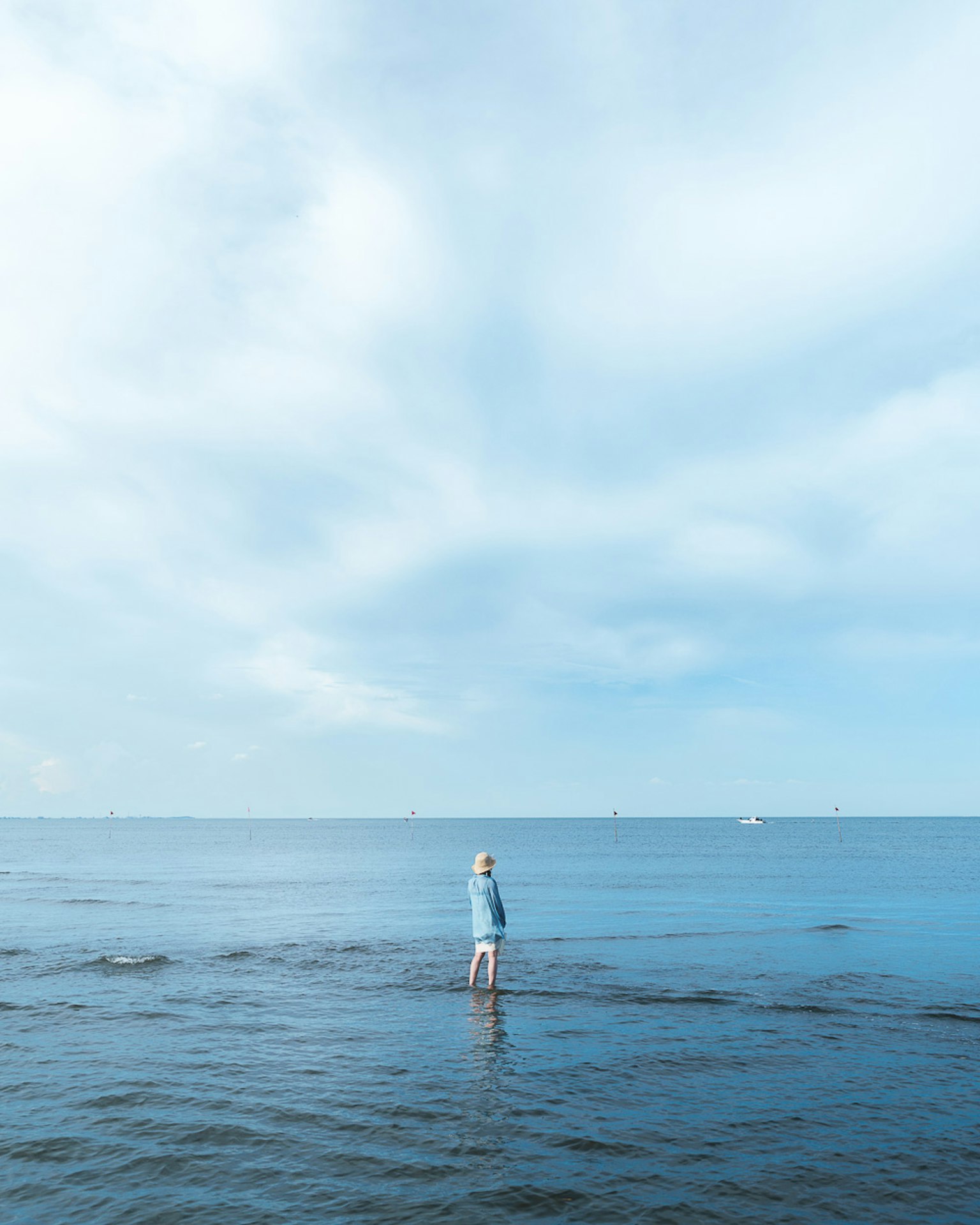 Silhouette of a person standing in blue ocean water