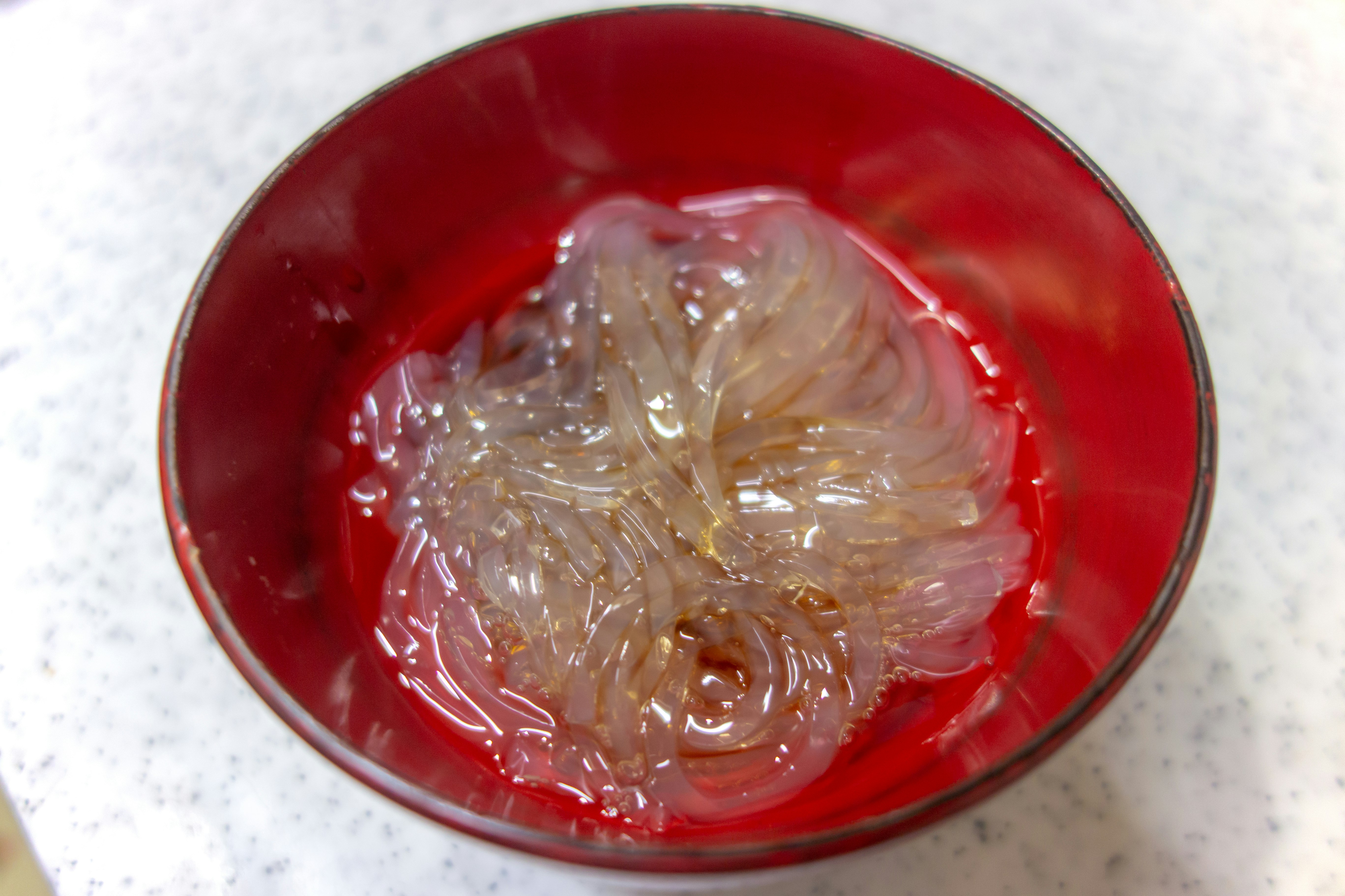 紅色碗裡的透明果凍狀食物