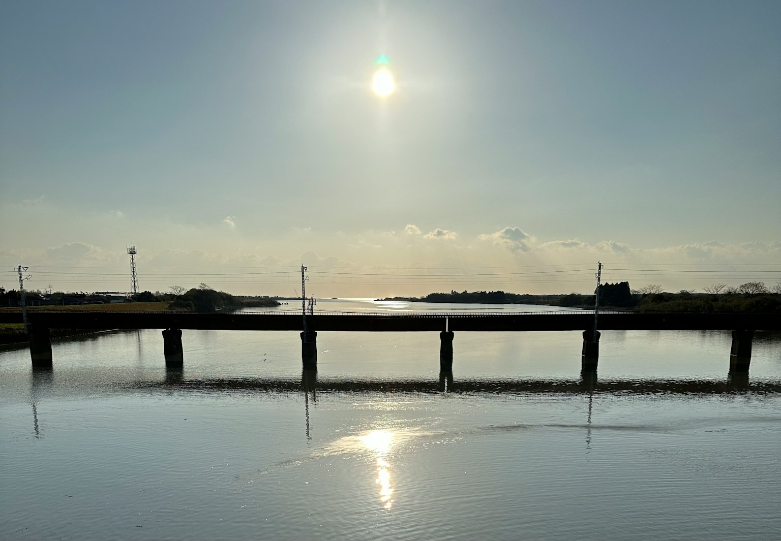 Cây cầu phản chiếu trên mặt nước yên tĩnh dưới ánh nắng chói chang