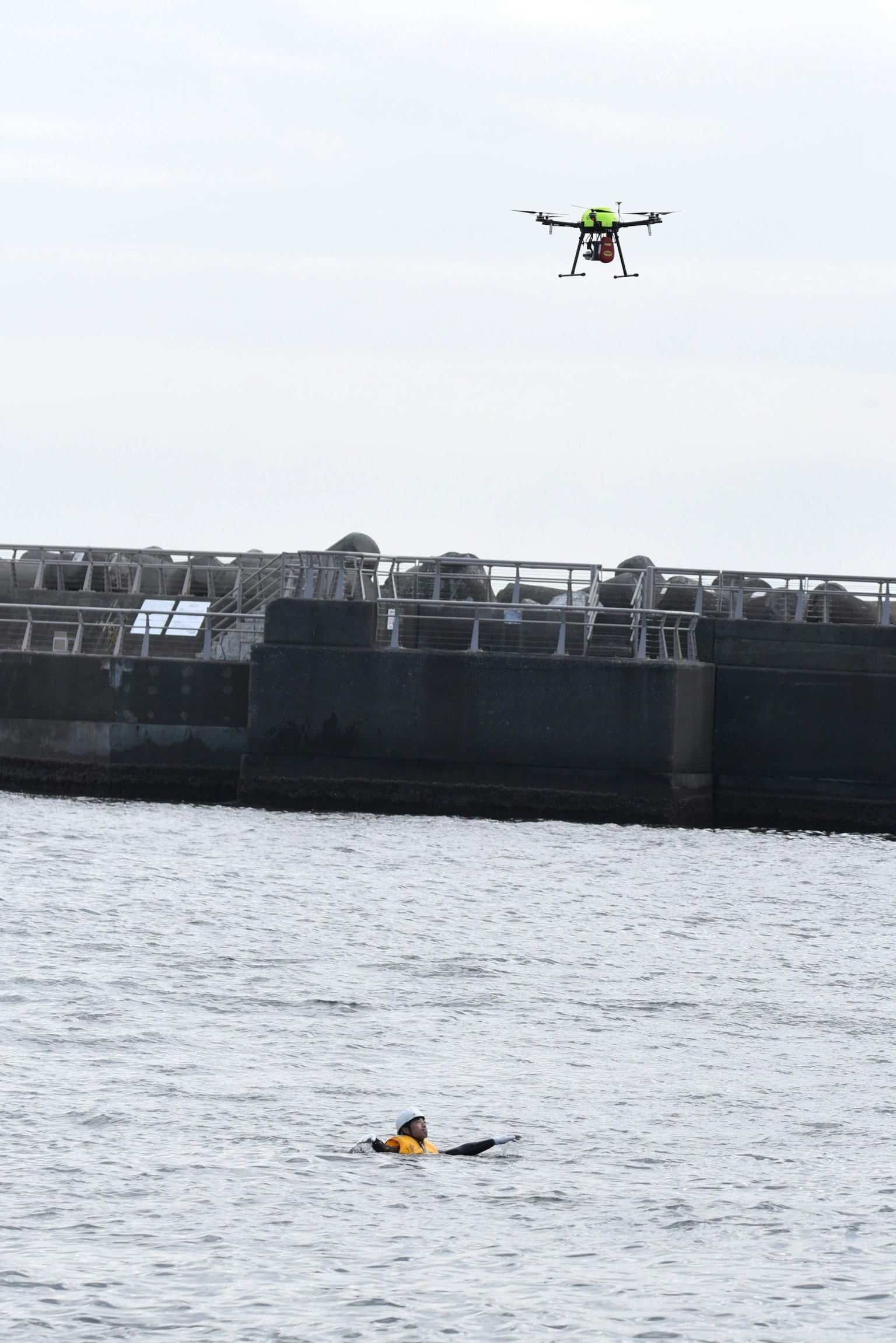 Seseorang yang berenang di air dengan drone terbang di atasnya