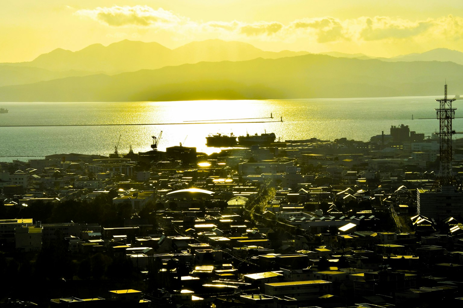Scenic view of a town with sunset reflecting on the sea