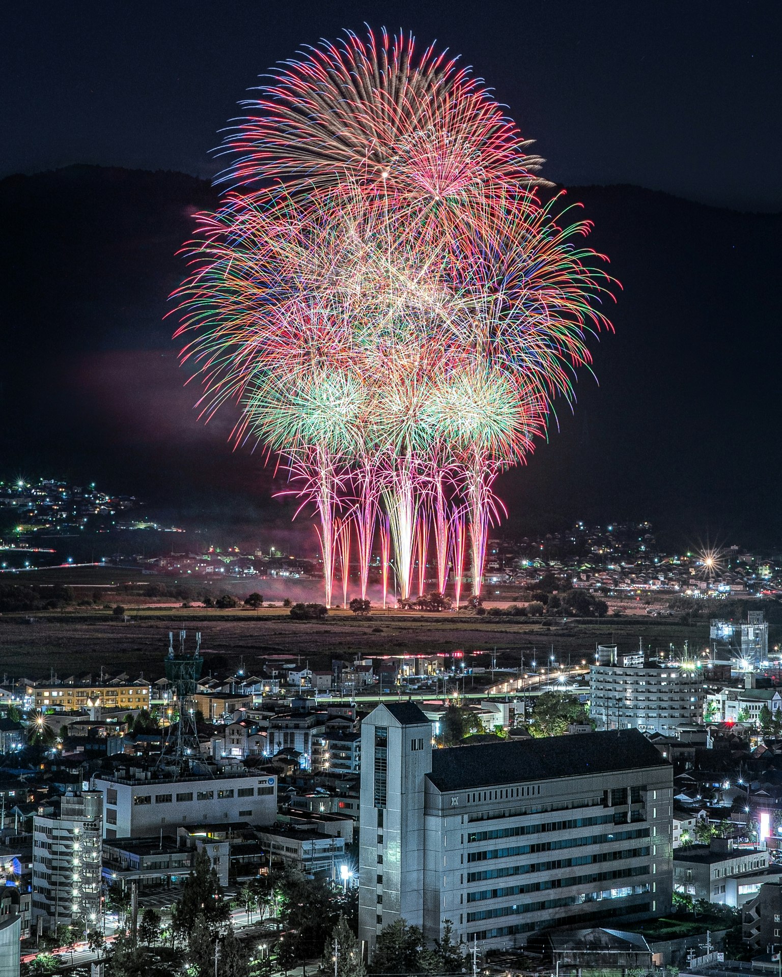 五颜六色的烟花表演照亮夜空，城市景观