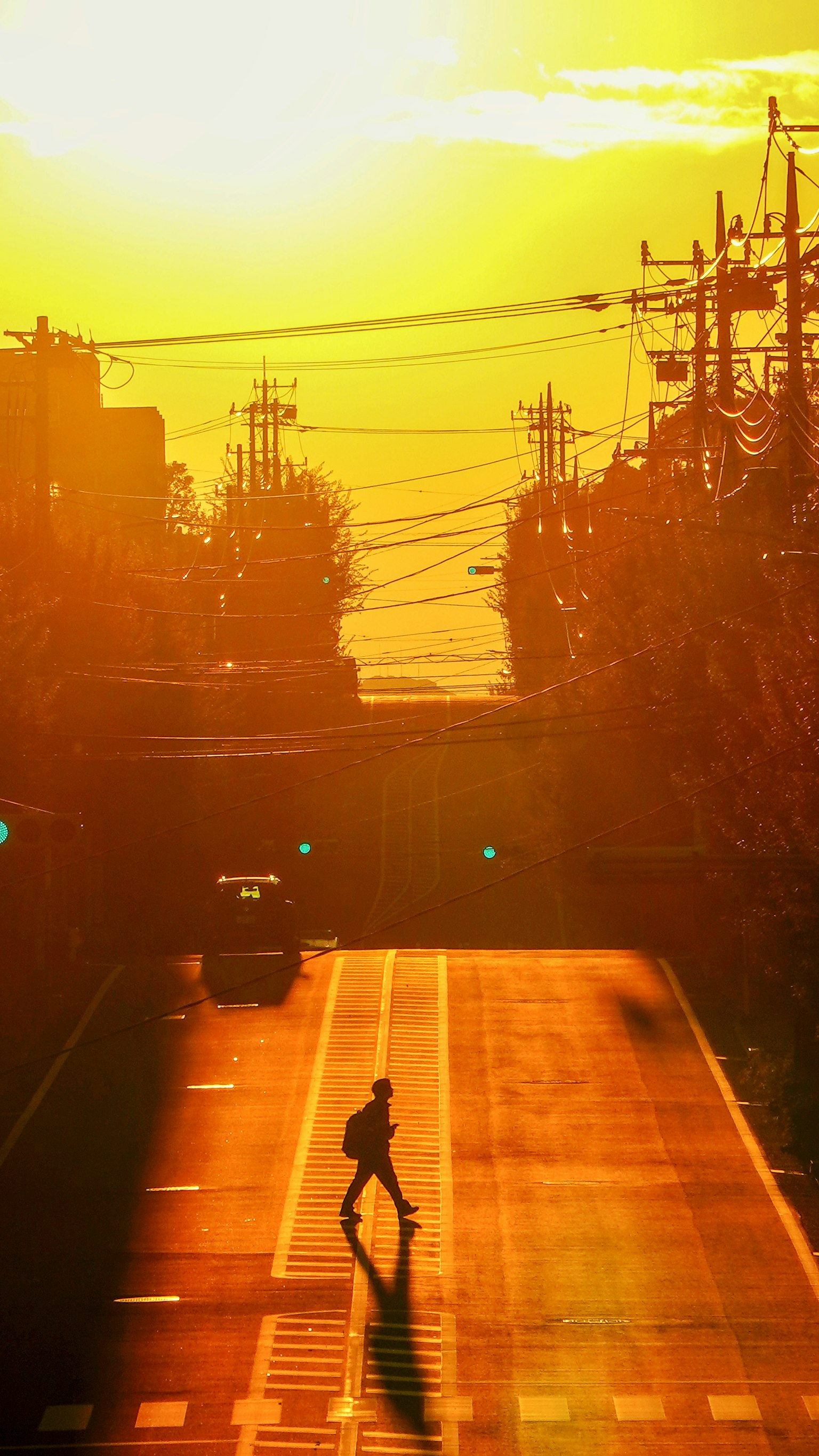 เงาของคนเดินอยู่บนถนนในขณะที่พระอาทิตย์ตก