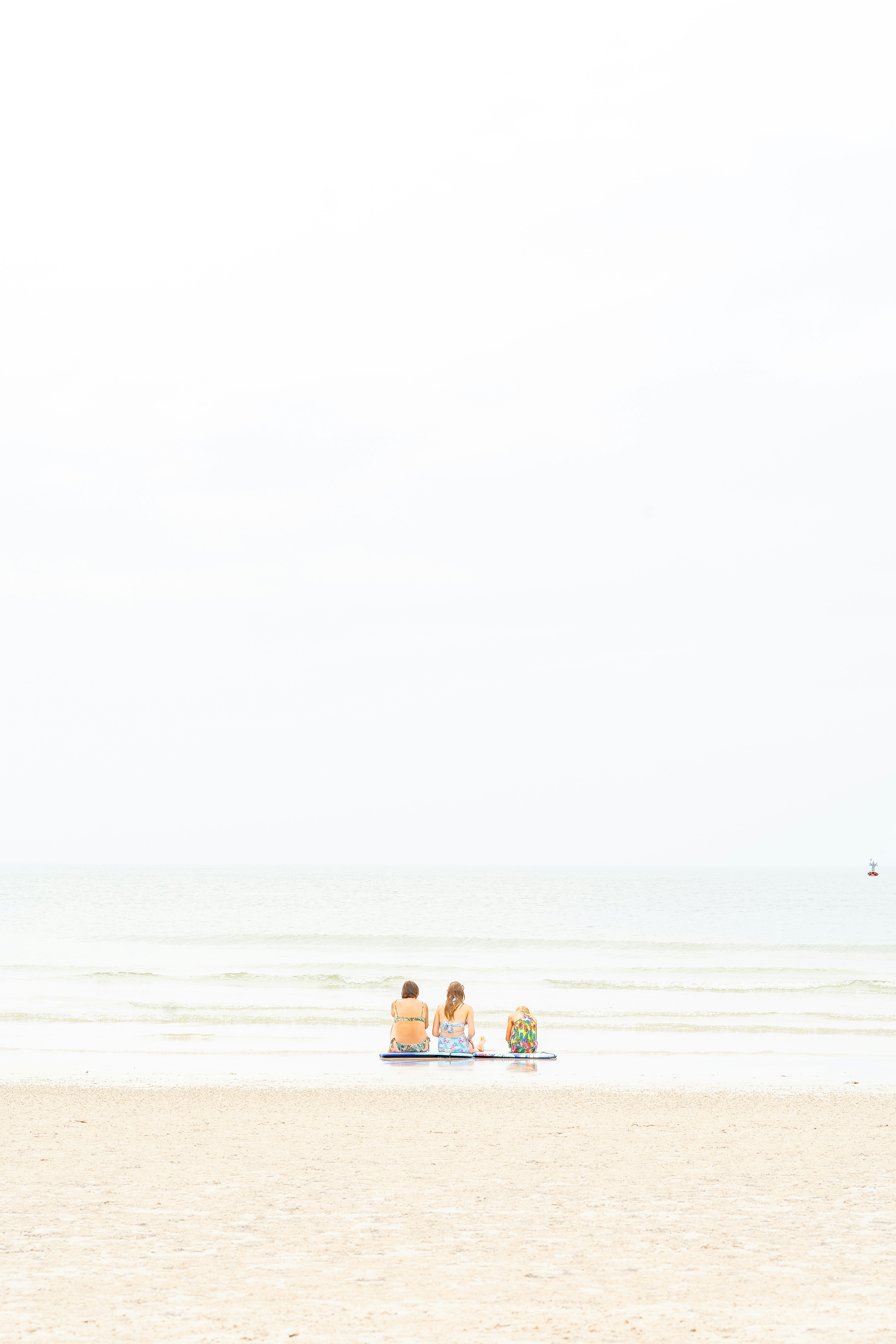 海辺で3人が並んで座るビーチの風景