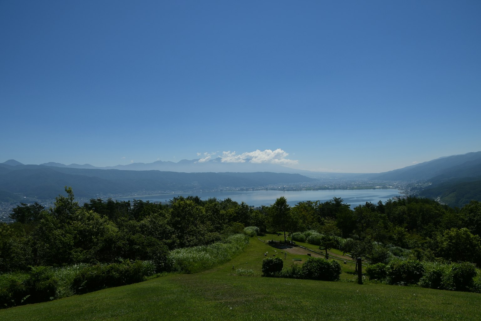 Vista panoramica di un paesaggio lussureggiante con lago e montagne sullo sfondo