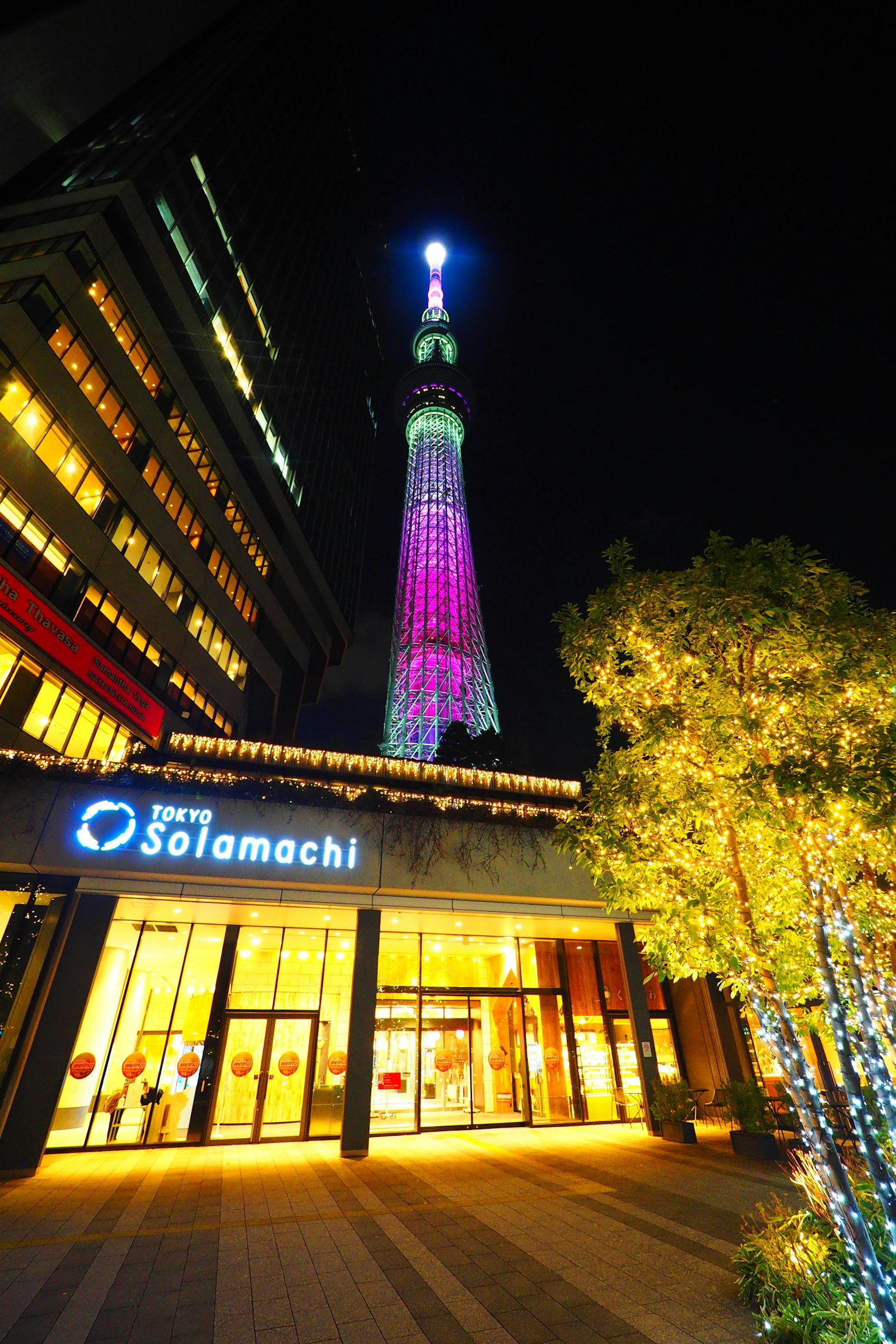 Tokyo Skytree iluminado por la noche con la entrada de Solamachi