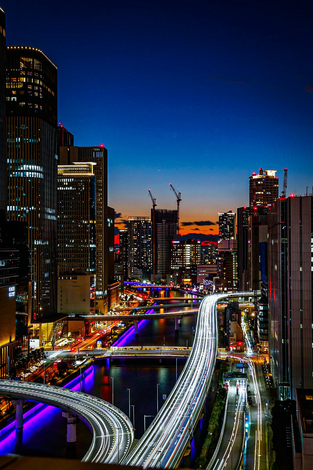 paisaje urbano nocturno con autopista elevada y rascacielos