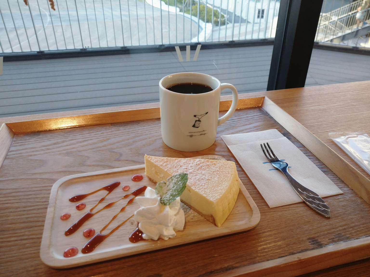 Kaffee und Käsekuchen auf einem Holztisch mit Aussicht