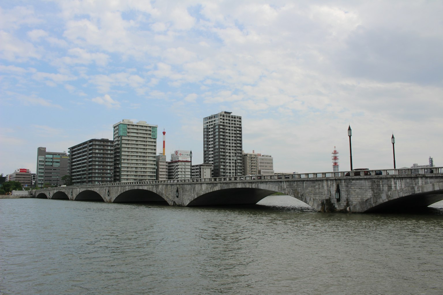 跨越河流的拱形桥和背景中的高楼大厦