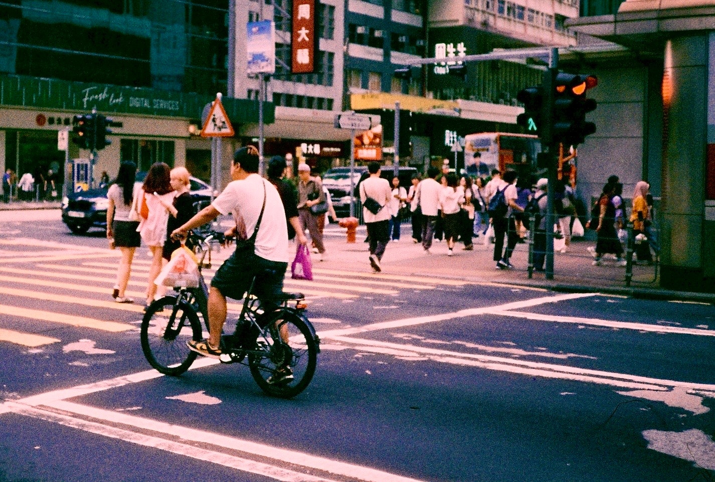 自転車に乗る人が行き交う交差点の街並み