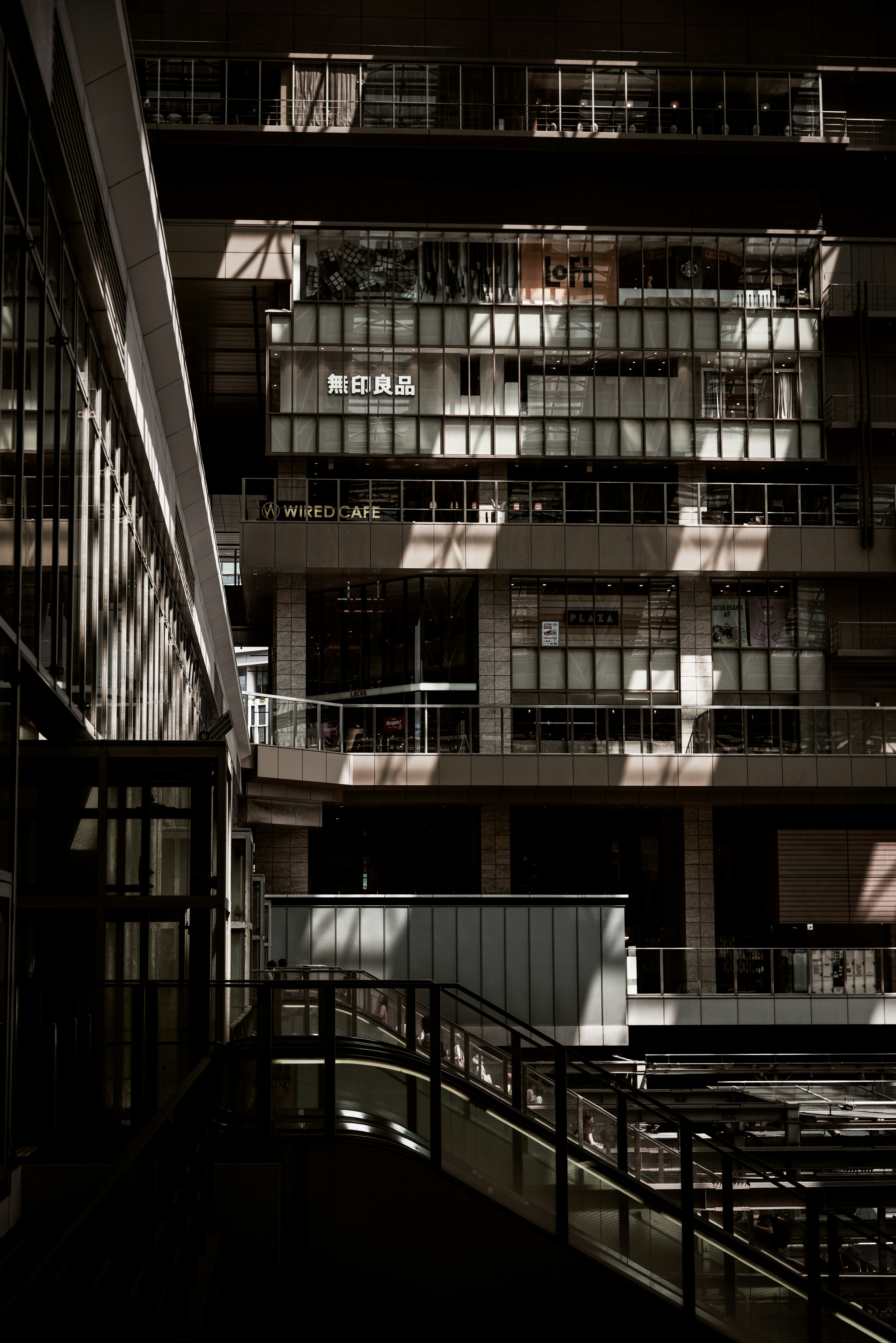 corridoio interno notturno e scala di fronte a un edificio a più piani