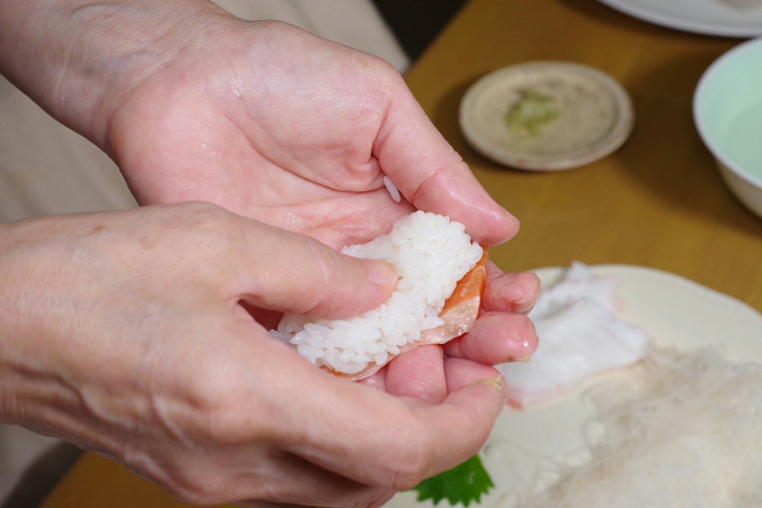 手正在製作海鮮壽司米飯