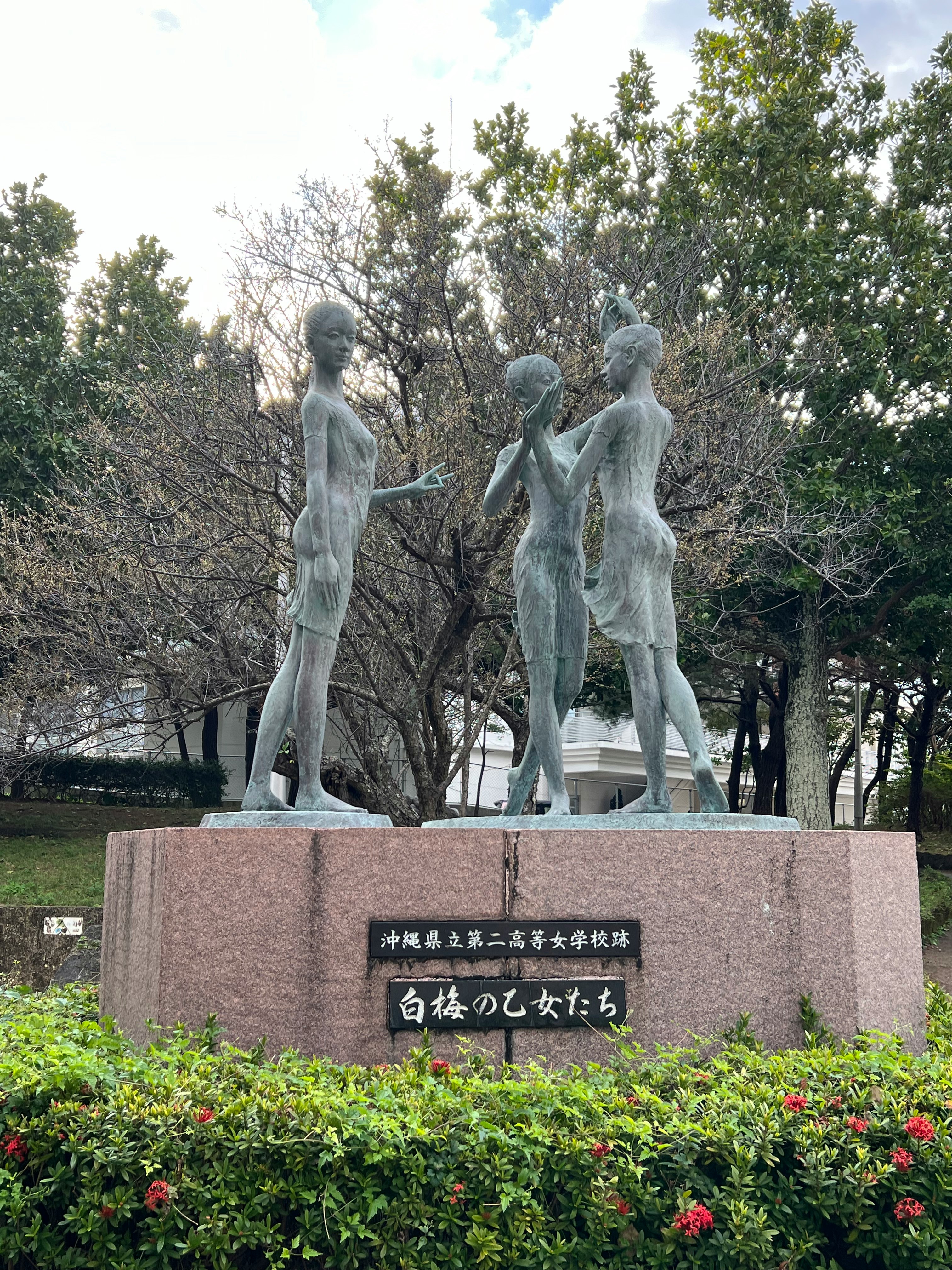 花壇の前に並ぶ女性像の彫刻
