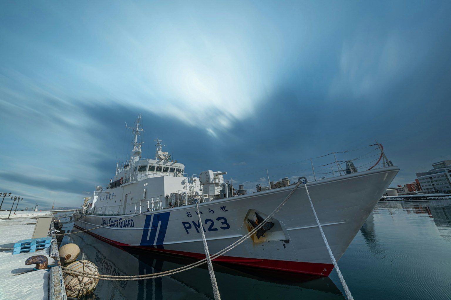 White ship P123 docked under a blue sky with visible details