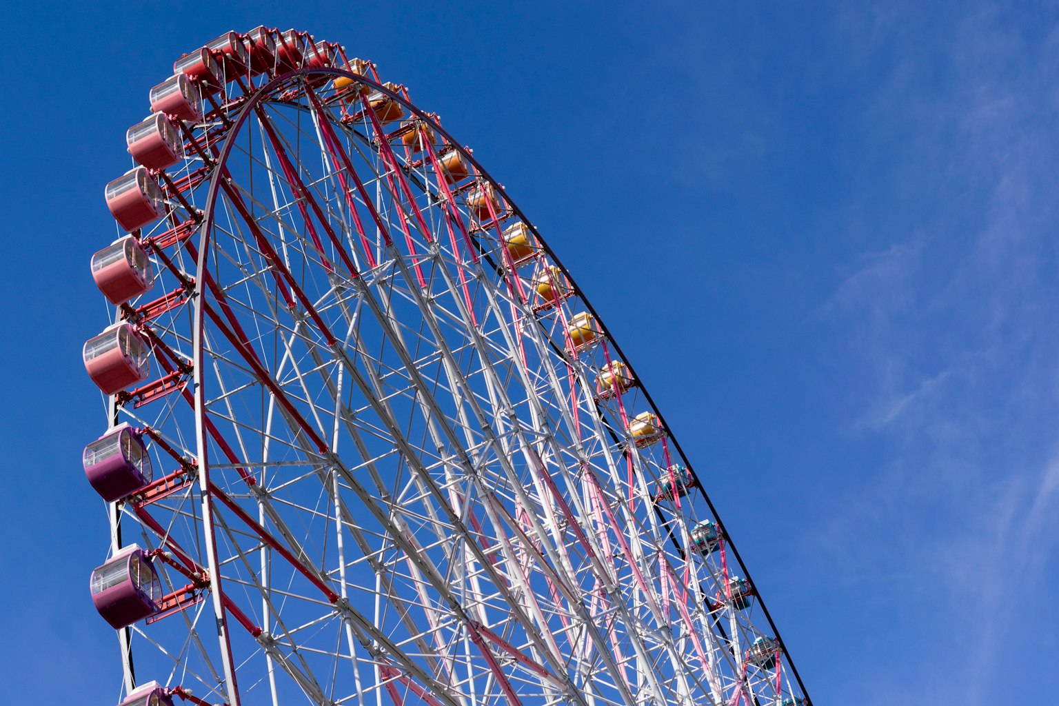 Close-up of a Ferris wheel against a blue sky