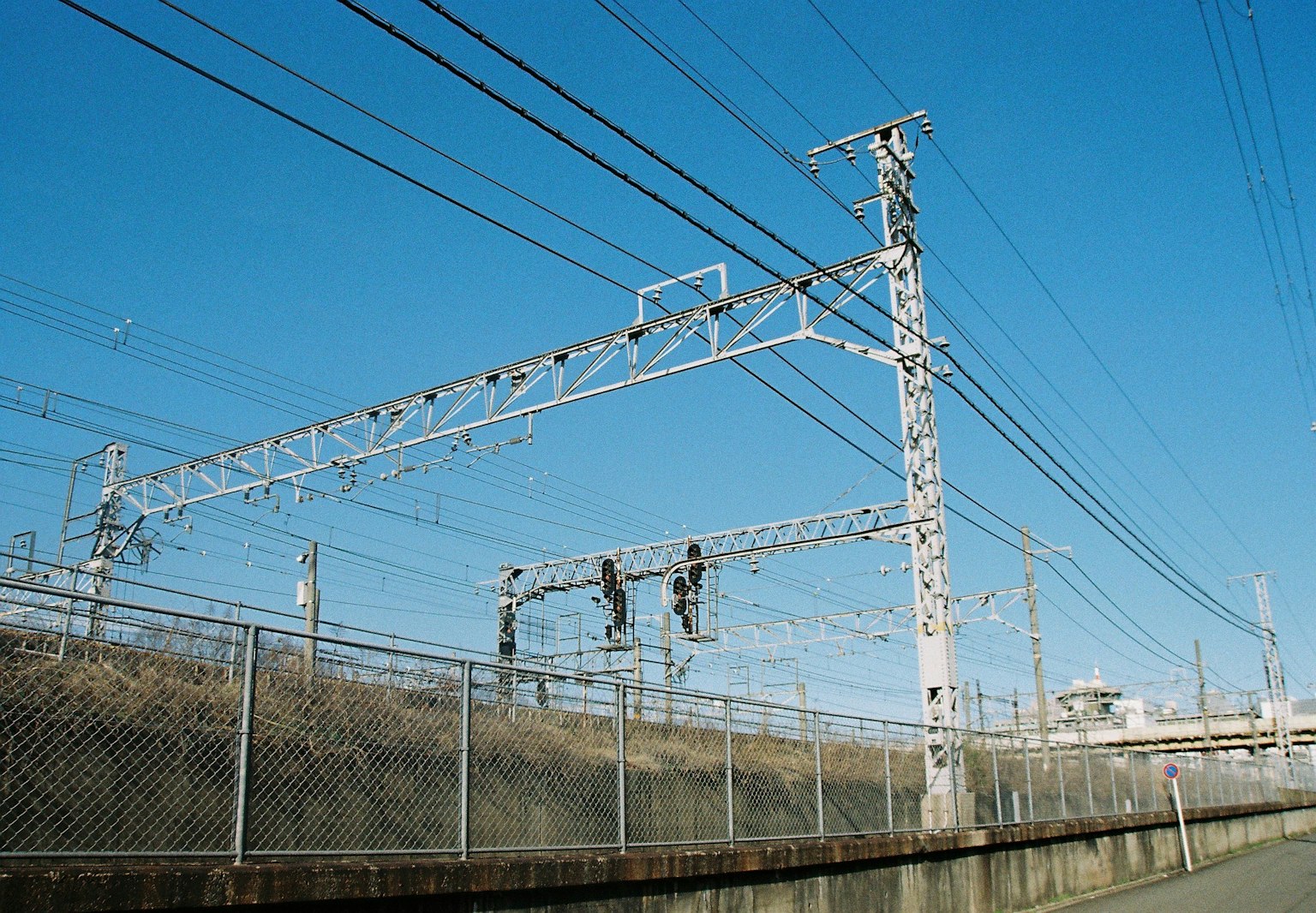 Linee ferroviarie aeree e recinzione sotto un cielo blu