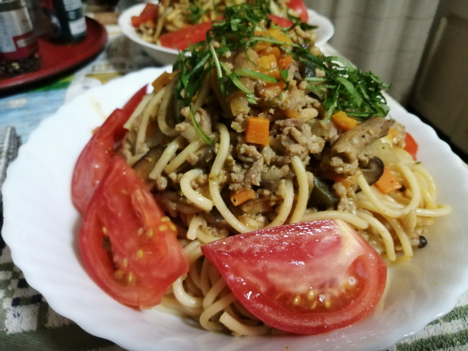 Plate of spaghetti topped with tomatoes and vegetables