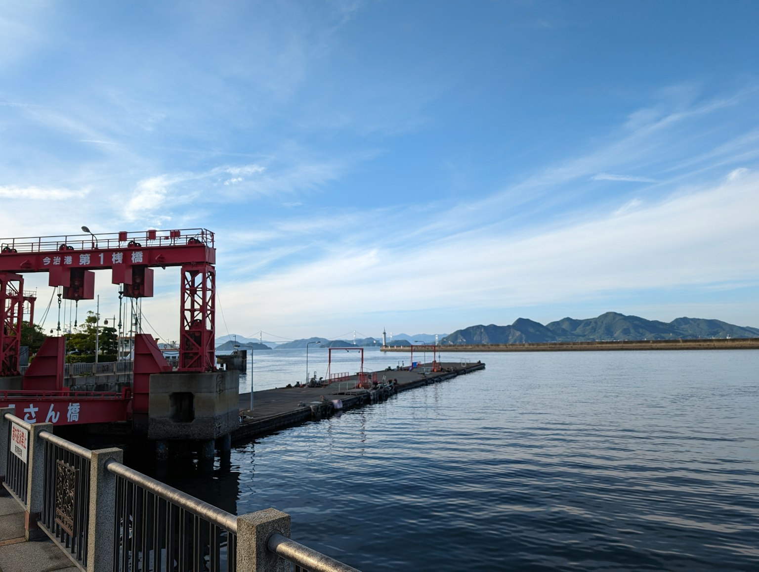 Pemandangan pelabuhan dengan struktur merah dan air tenang