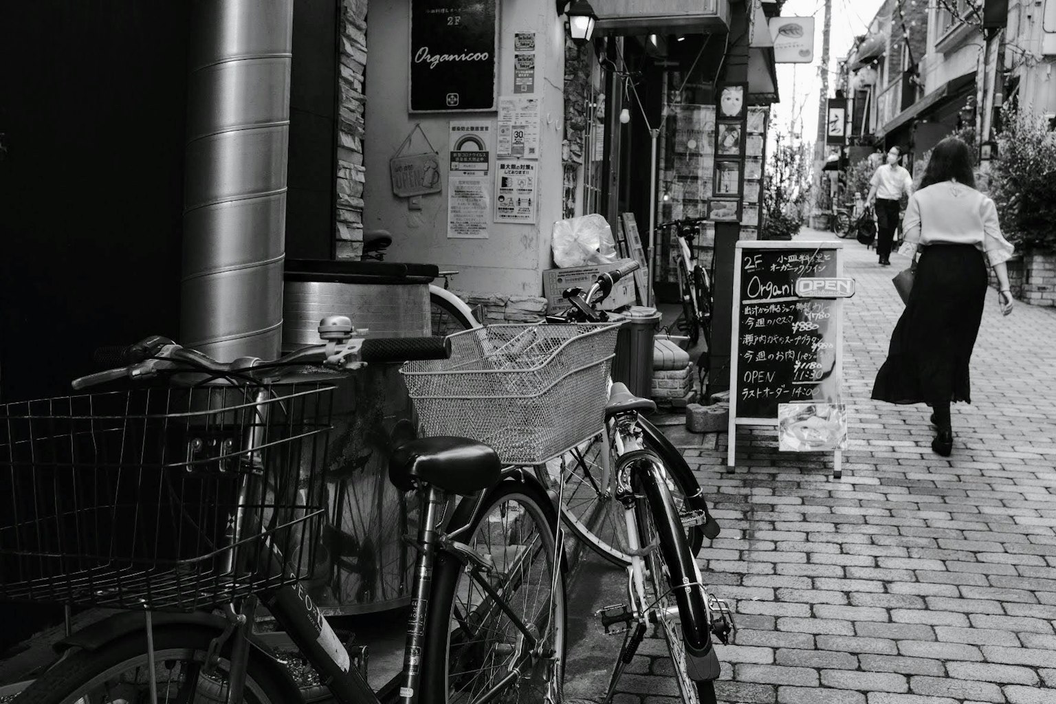ภาพถนนขาวดำที่มีจักรยานและคนเดิน