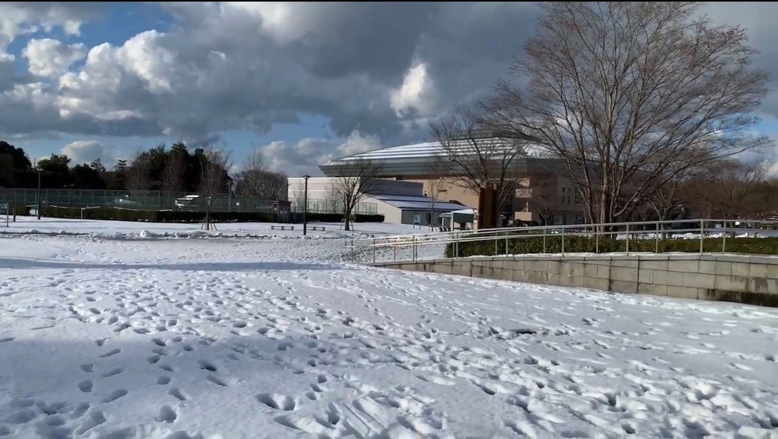 Paysage de parc couvert de neige avec un bâtiment en arrière-plan