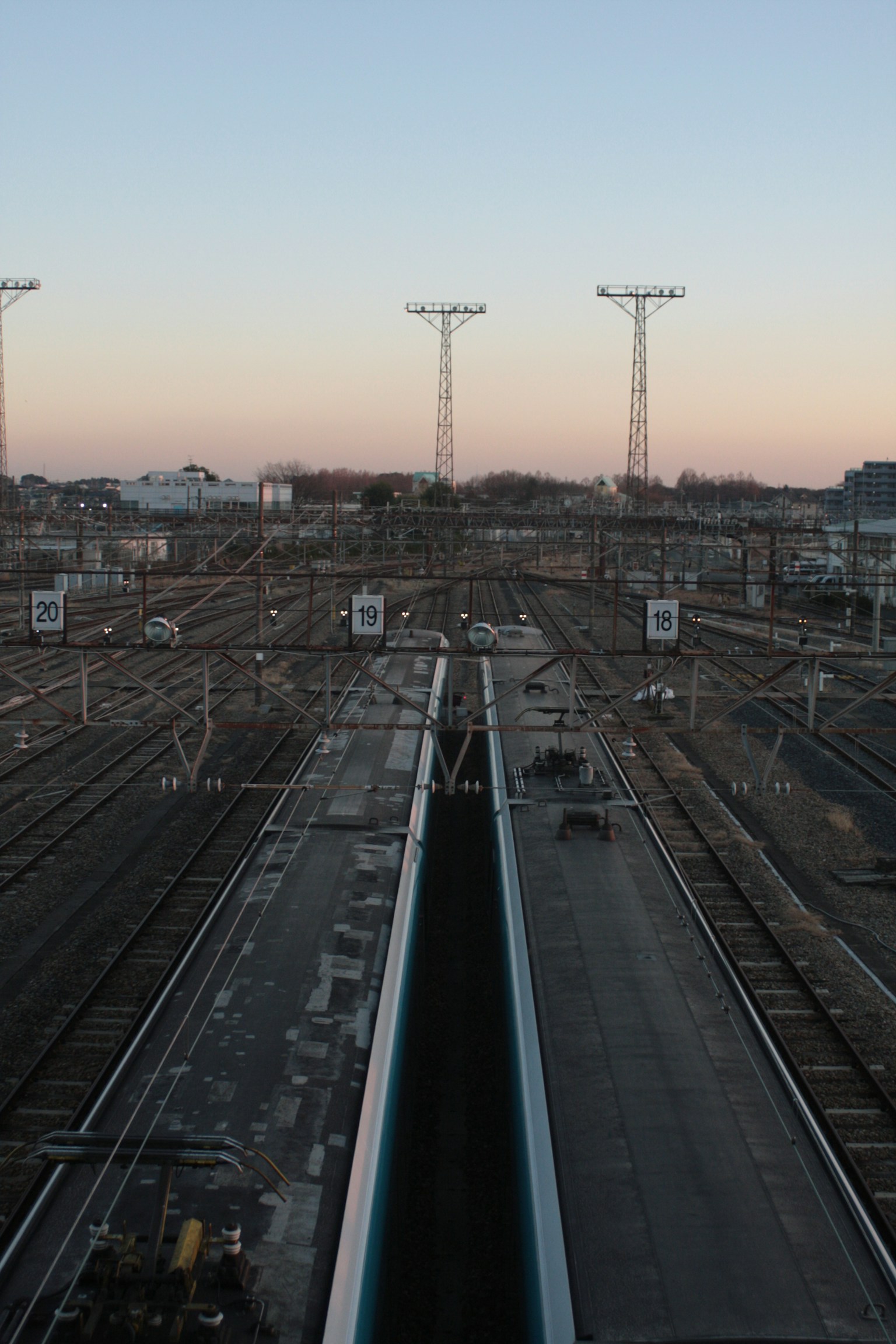 View of railway tracks at dusk with a clear sky