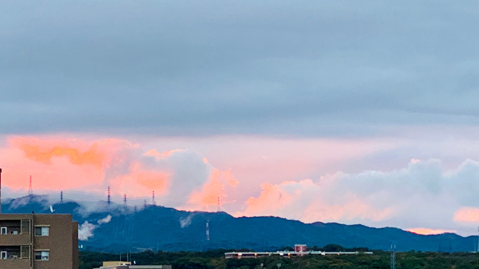 Paysage avec des nuages orange au-dessus des montagnes sous un ciel gris