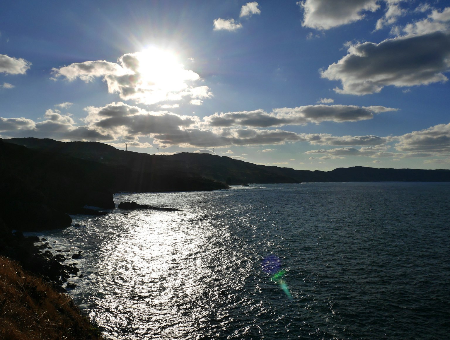 Malersiche Küstenansicht mit schimmerndem Wasser und hellem Sonnenlicht