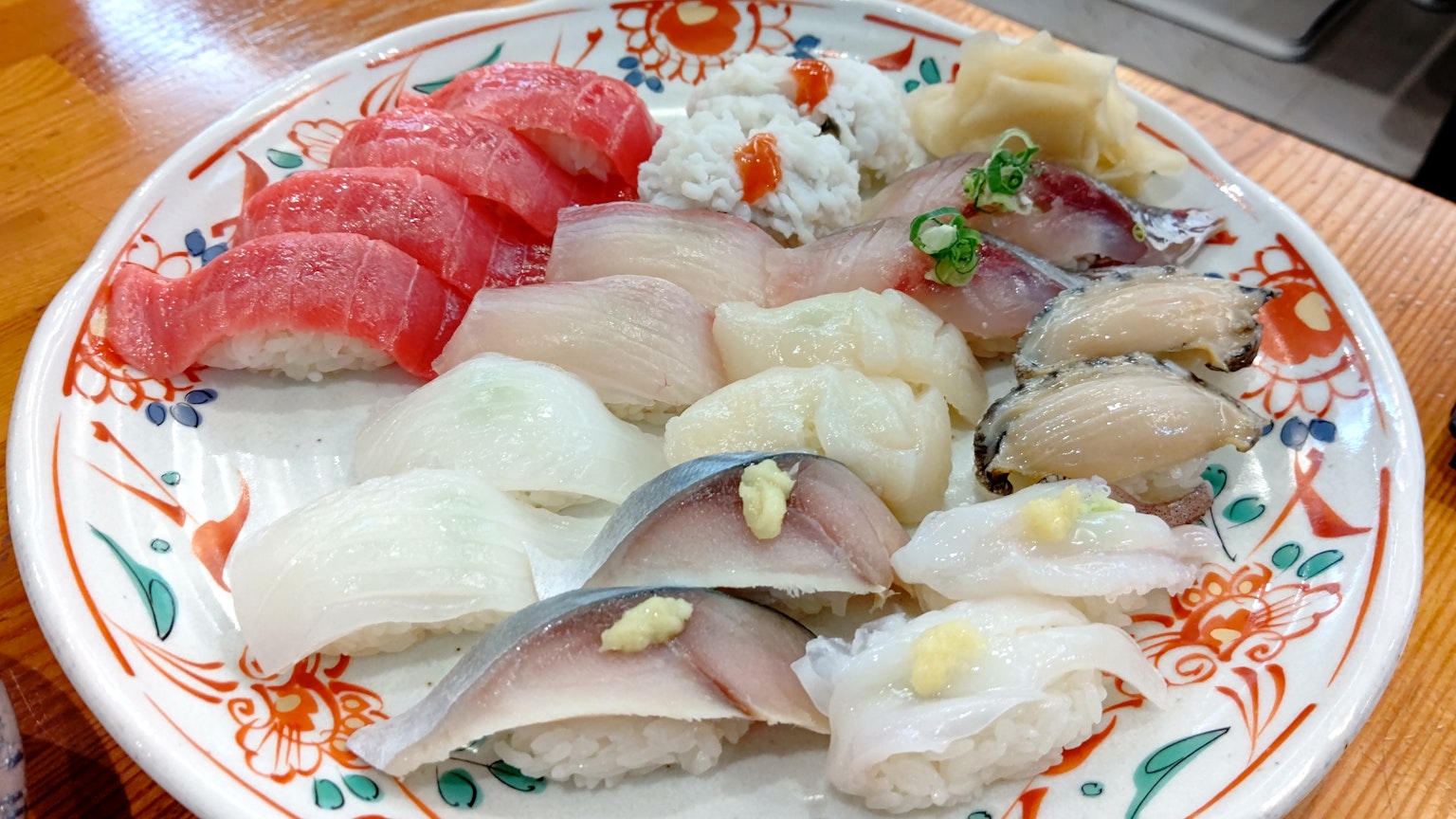 Piring sushi yang disusun dengan indah dengan berbagai jenis sushi