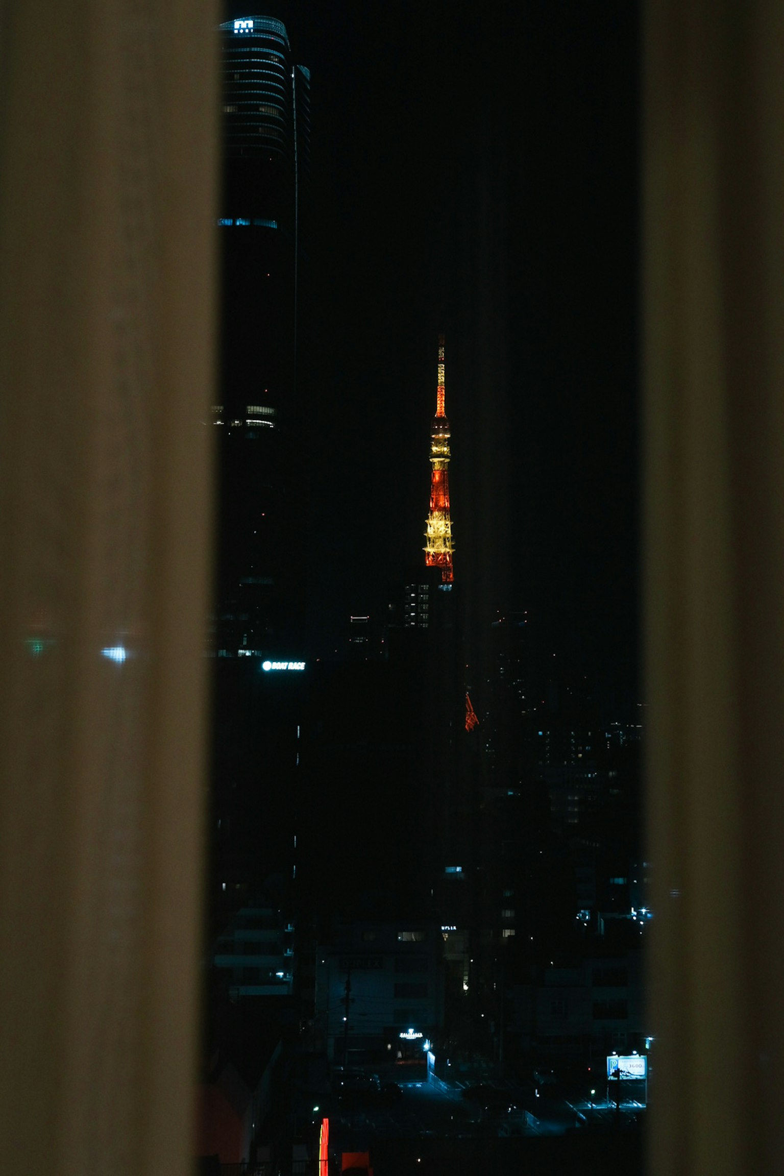 Tokio Tower bei Nacht durch Vorhänge gesehen