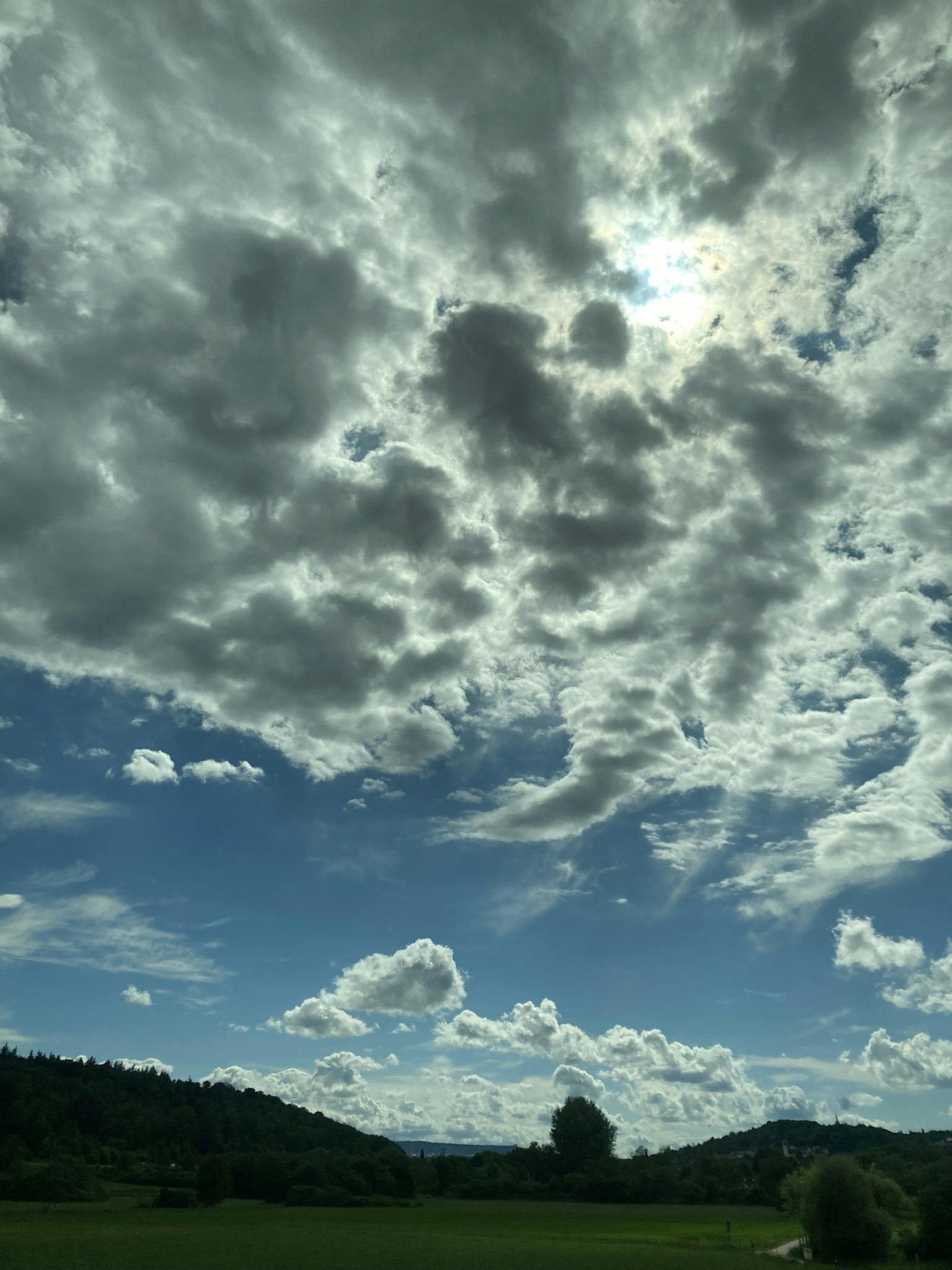Un paysage avec un ciel bleu et des nuages des collines vertes et de l'herbe
