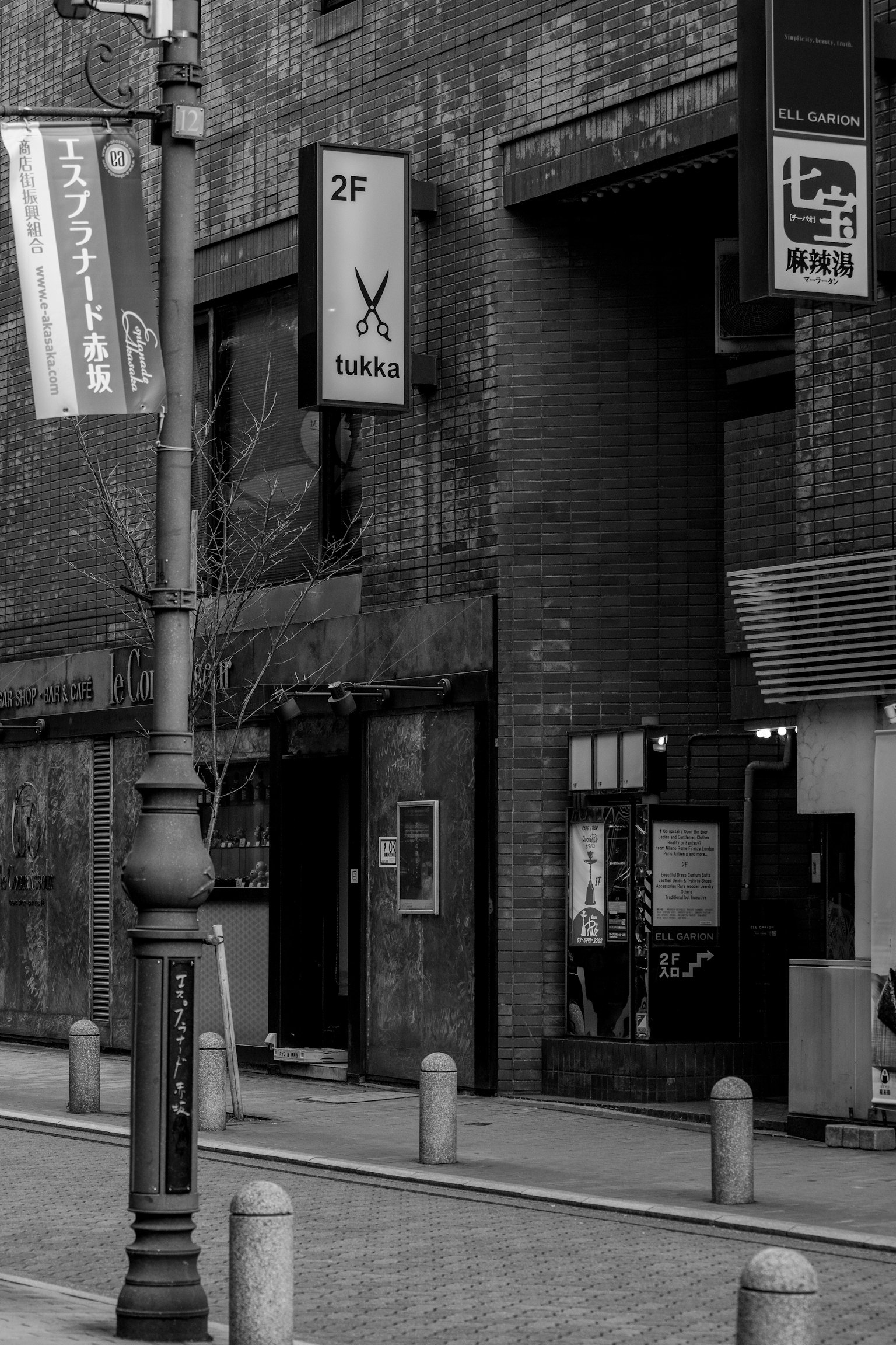 Black and white street scene featuring a sign and building exterior
