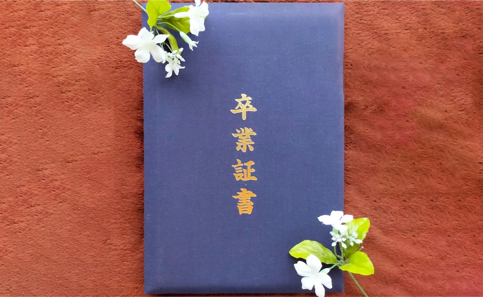 藍色畢業證書與白色花朵設計