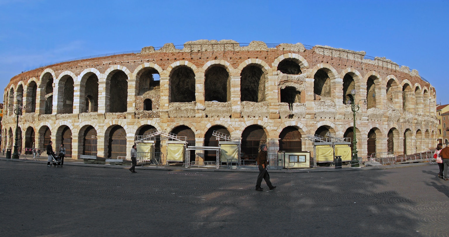 Exterior view of an ancient Roman amphitheater featuring arches and stone structure