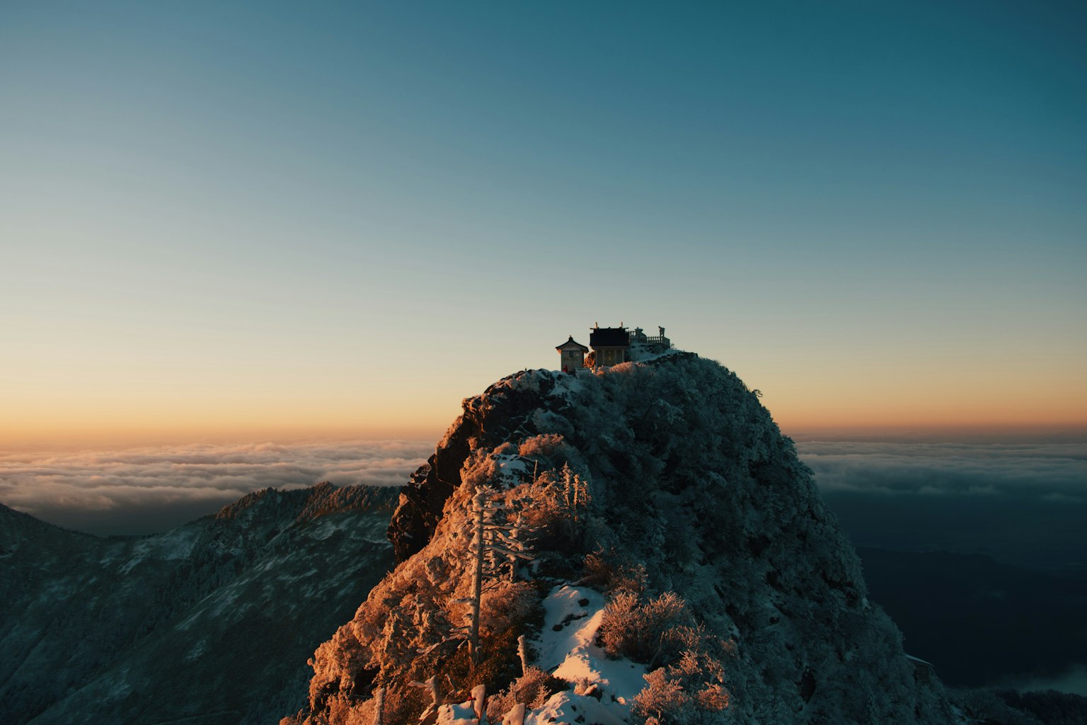 Snow-covered mountain peak with a stunning sunset