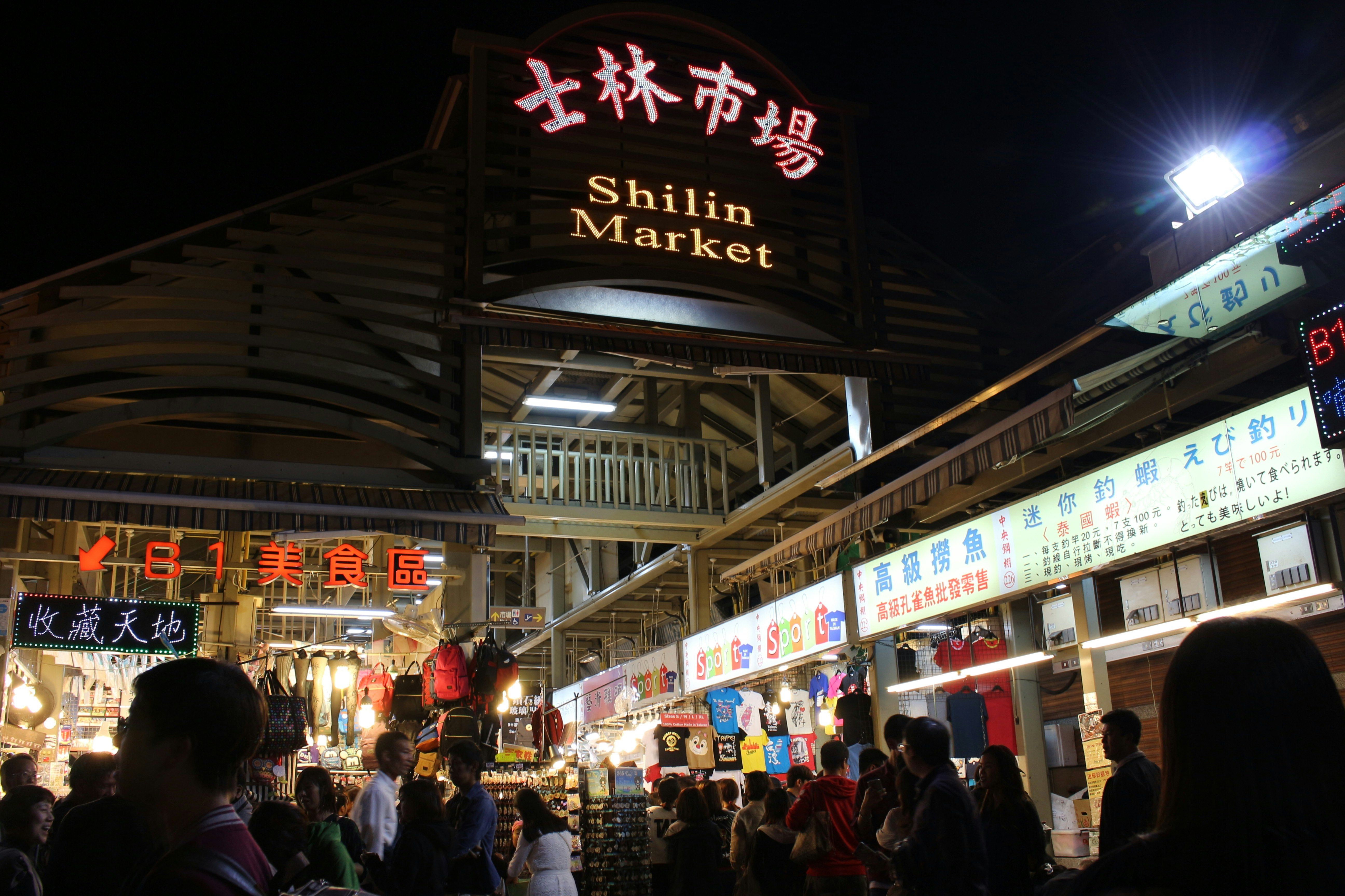 allée de marché nocturne au Shilin Market avec enseignes et stands