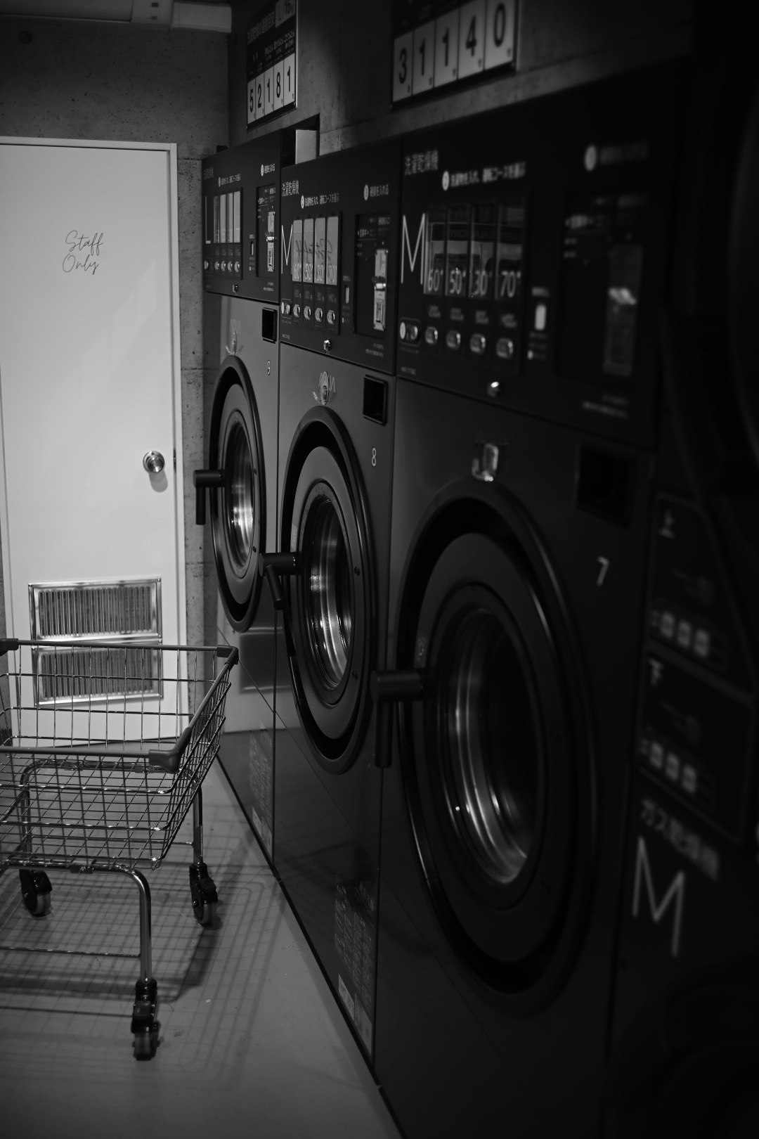 indoor laundry room with coin-operated washing machines lined up