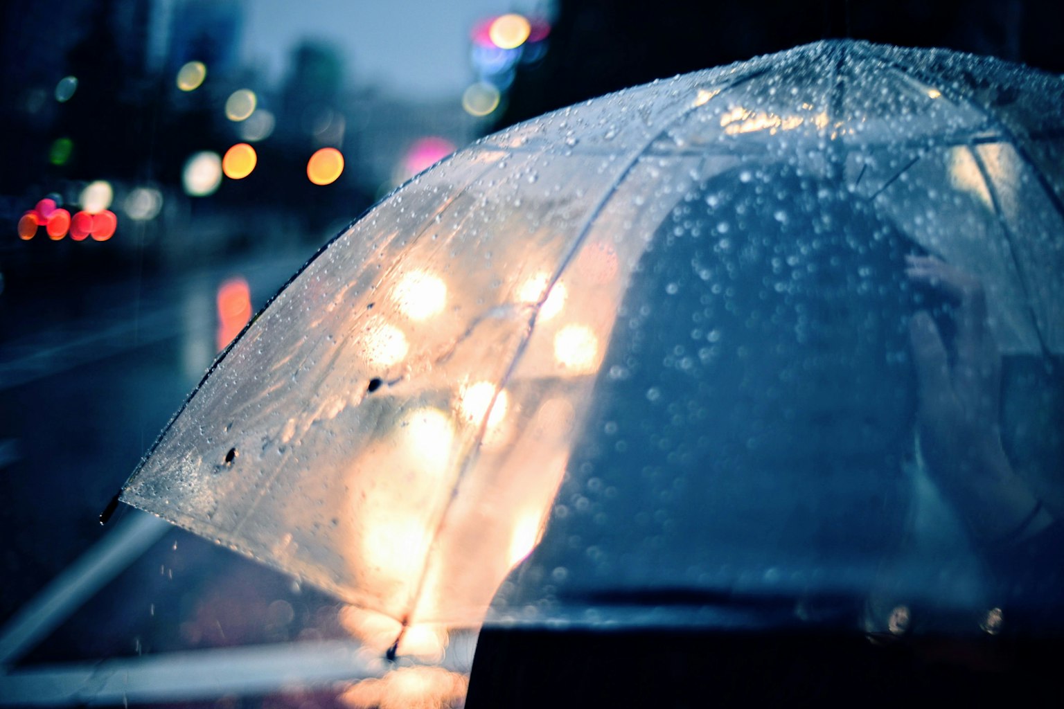 雨中的透明伞和模糊的城市灯光