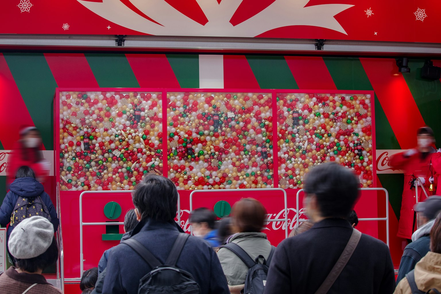 Persone riunite davanti a un'esposizione natalizia festiva con decorazioni colorate