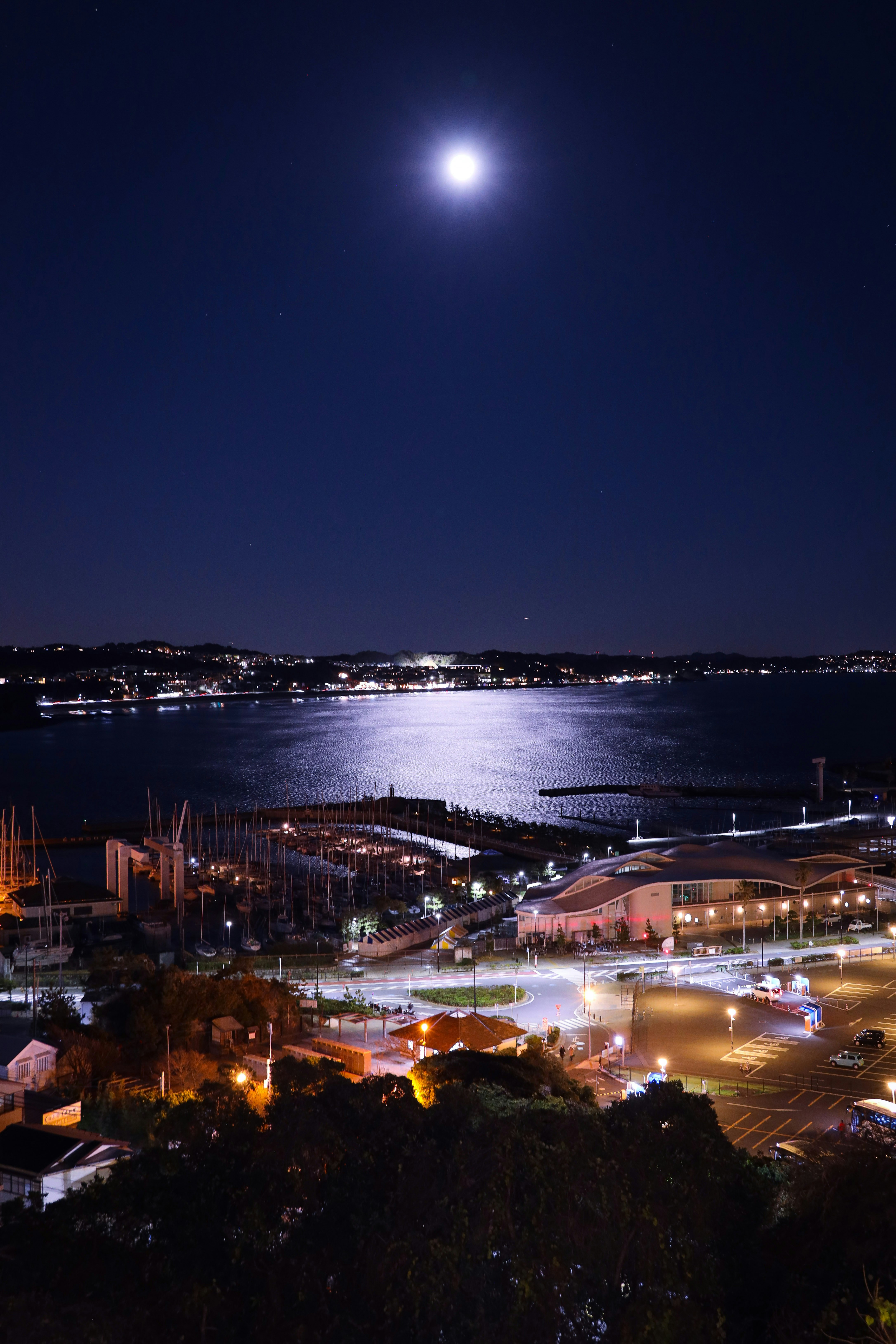 Vista notturna di Enoshima con la luna sopra la passeggiata sul mare