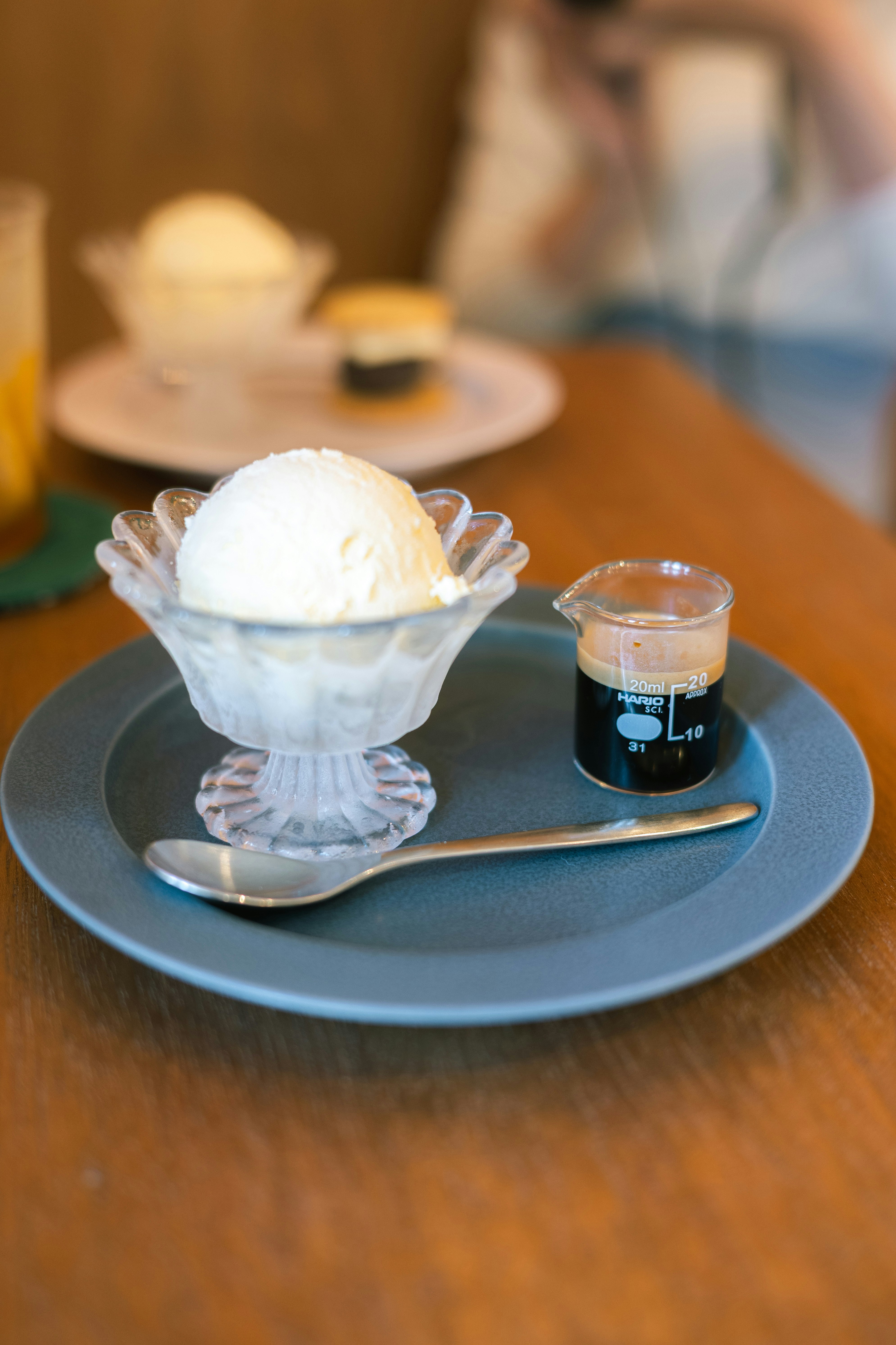青いトレイにのった白いデザートと小さなコーヒー