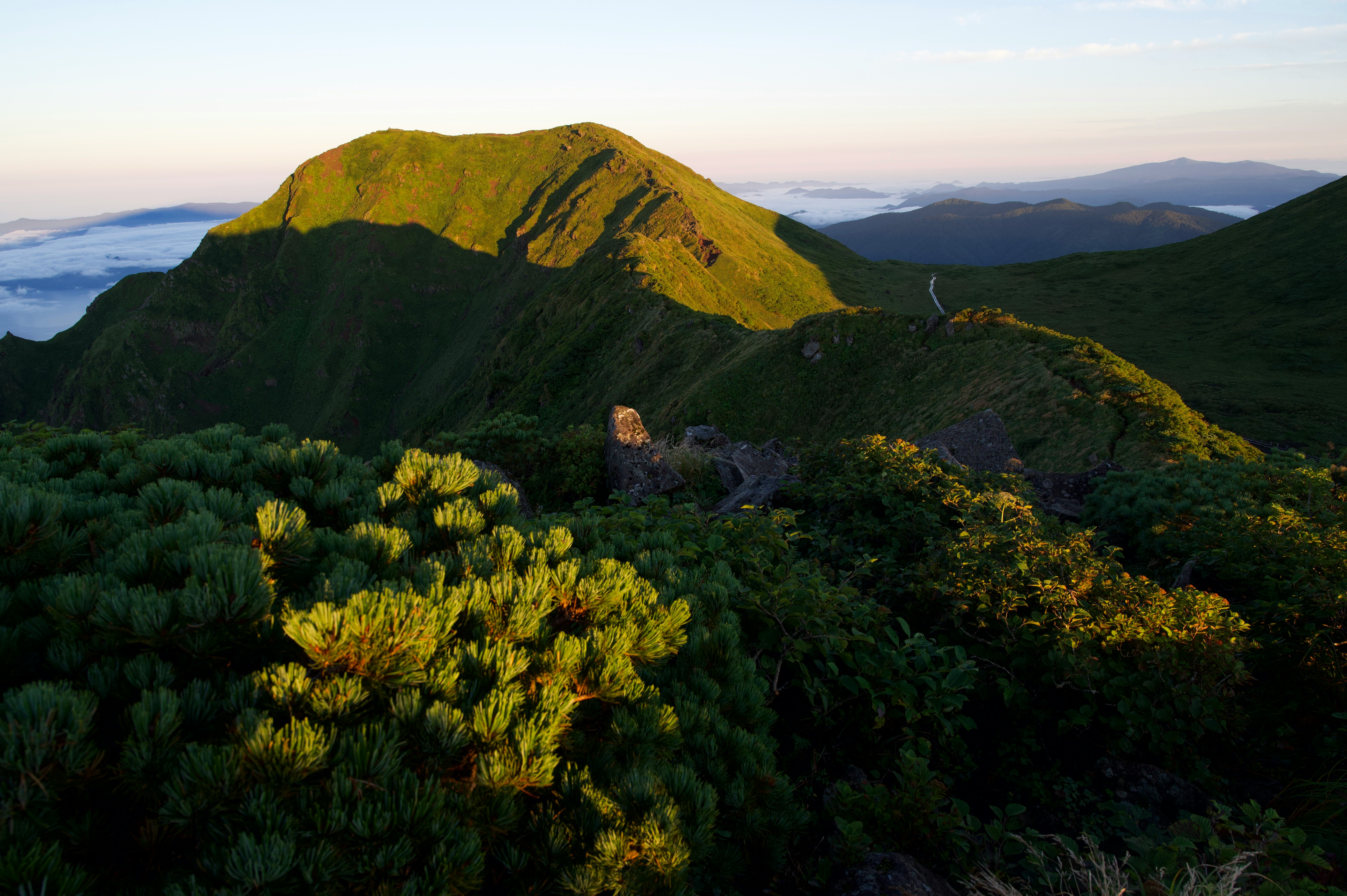 paisaje de cresta montañosa al atardecer con colinas verdes exuberantes