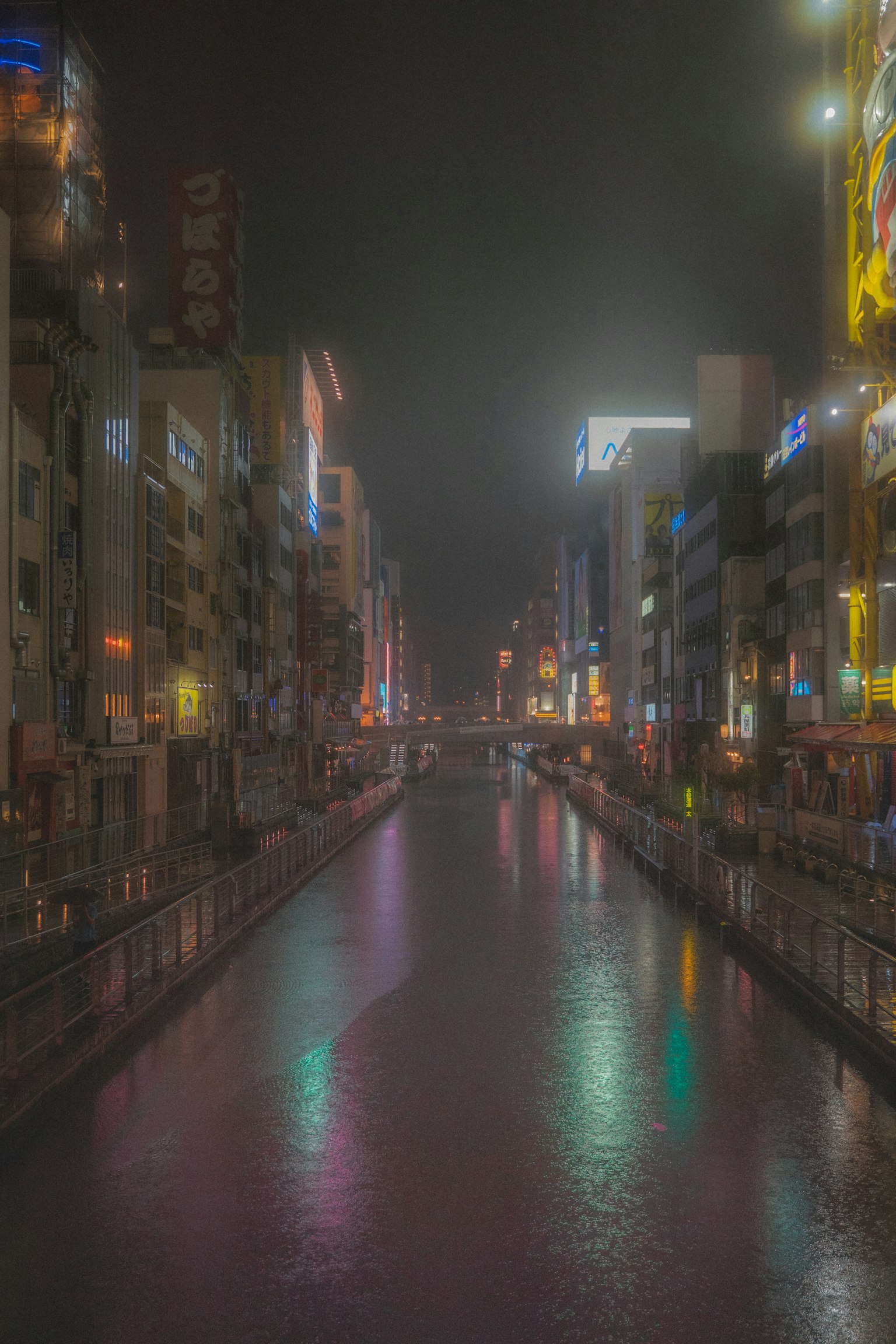 夜の川沿いの街並み 美しいネオンの光が反射する