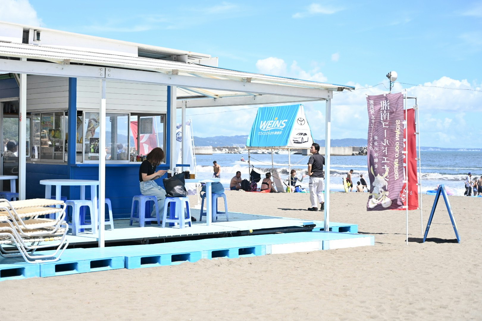 海の家の青いベンチとビーチの風景