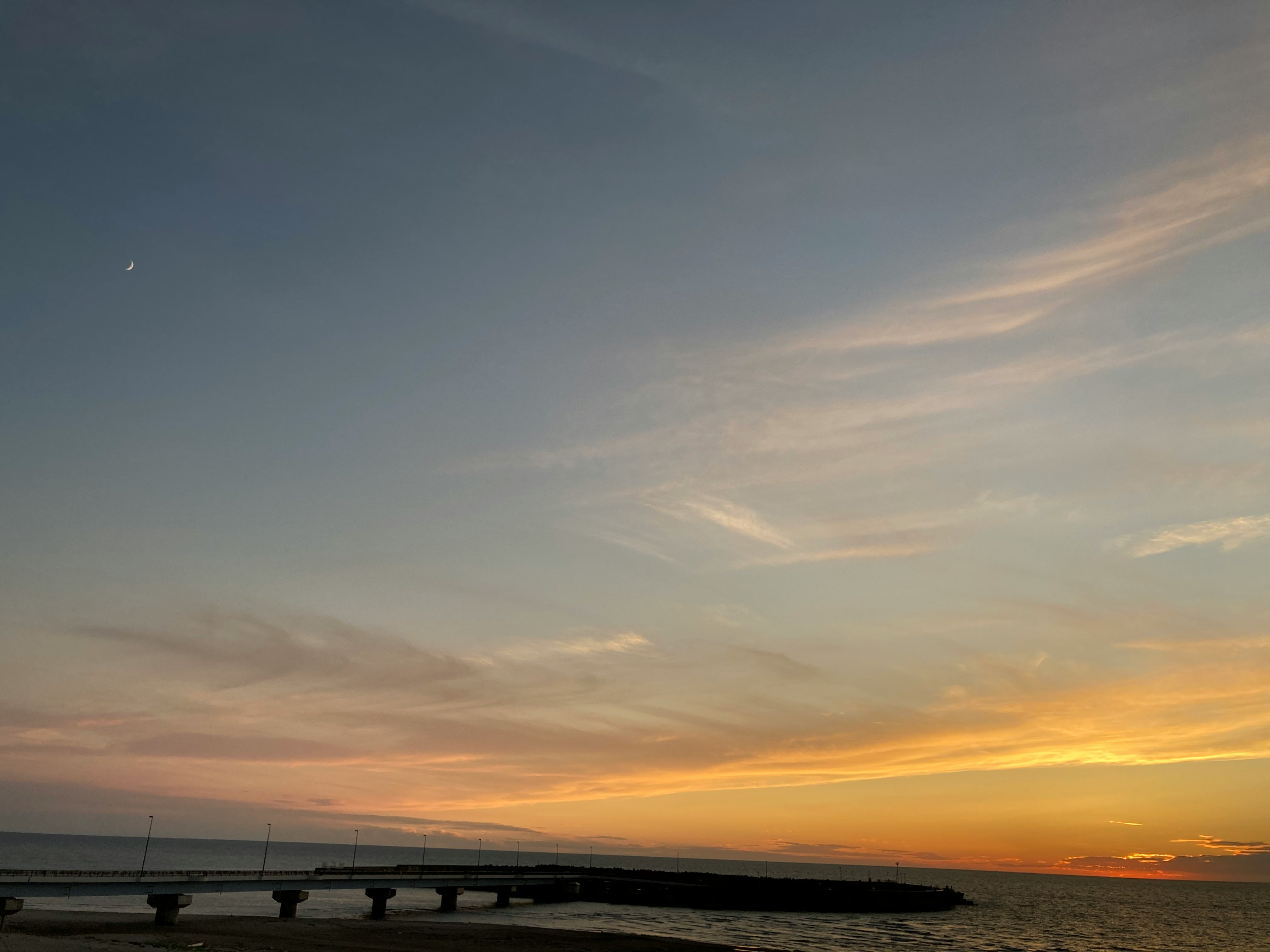 水平線に伸びる防波堤と夕焼けの空