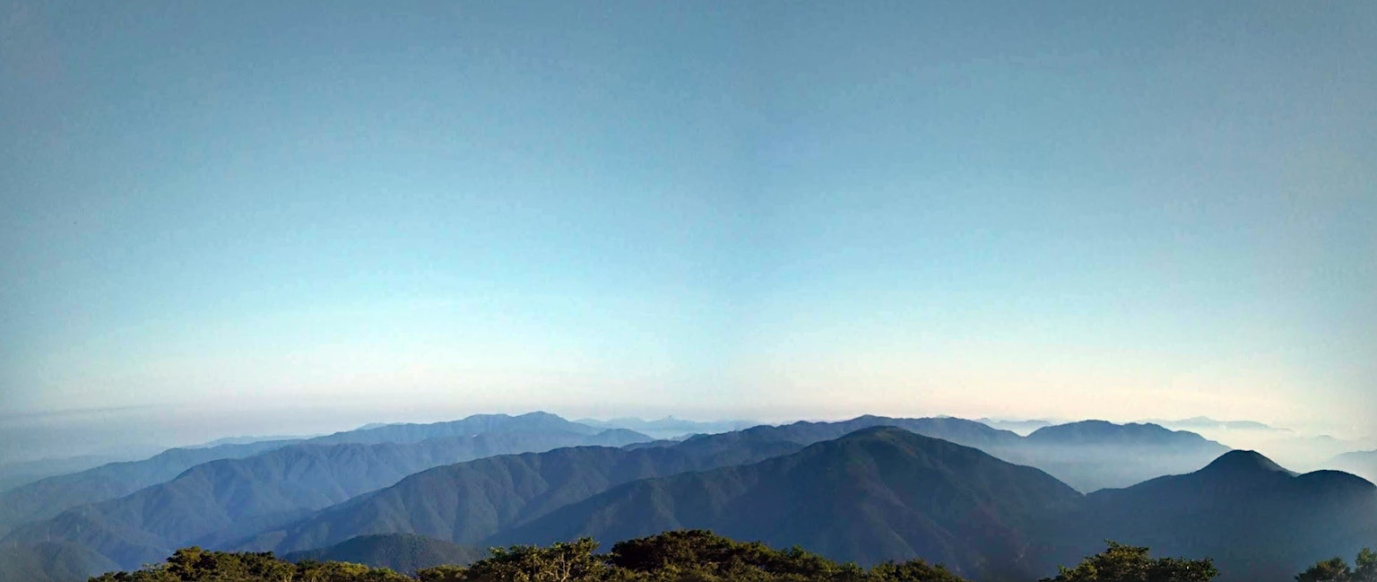 Pemandangan pegunungan panorama di bawah langit biru yang cerah